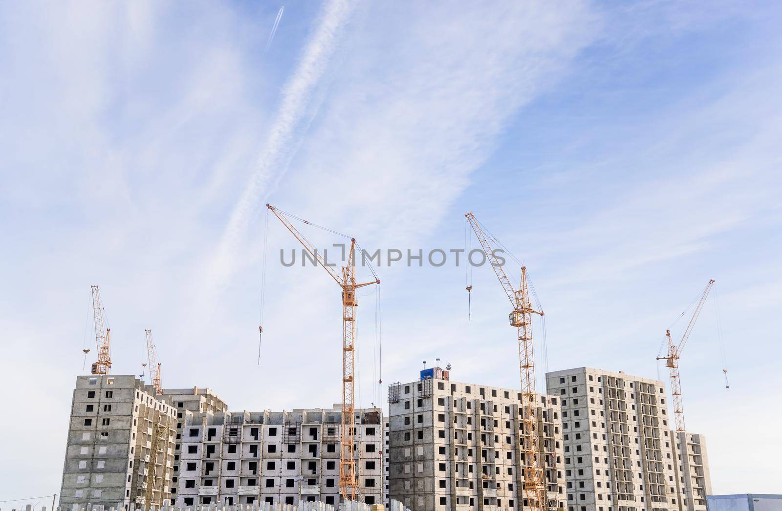 Construction site with cranes on sky background.
