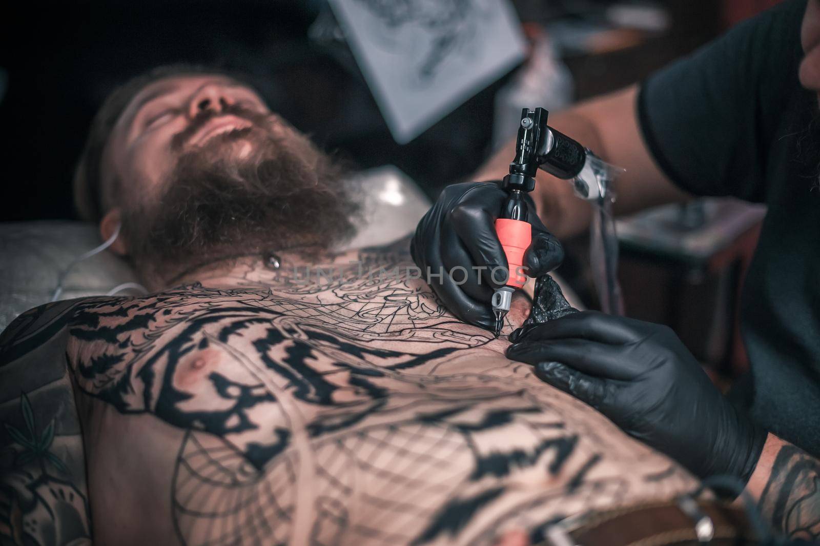 Tattooer makes cool tattoo in the salon by Proff