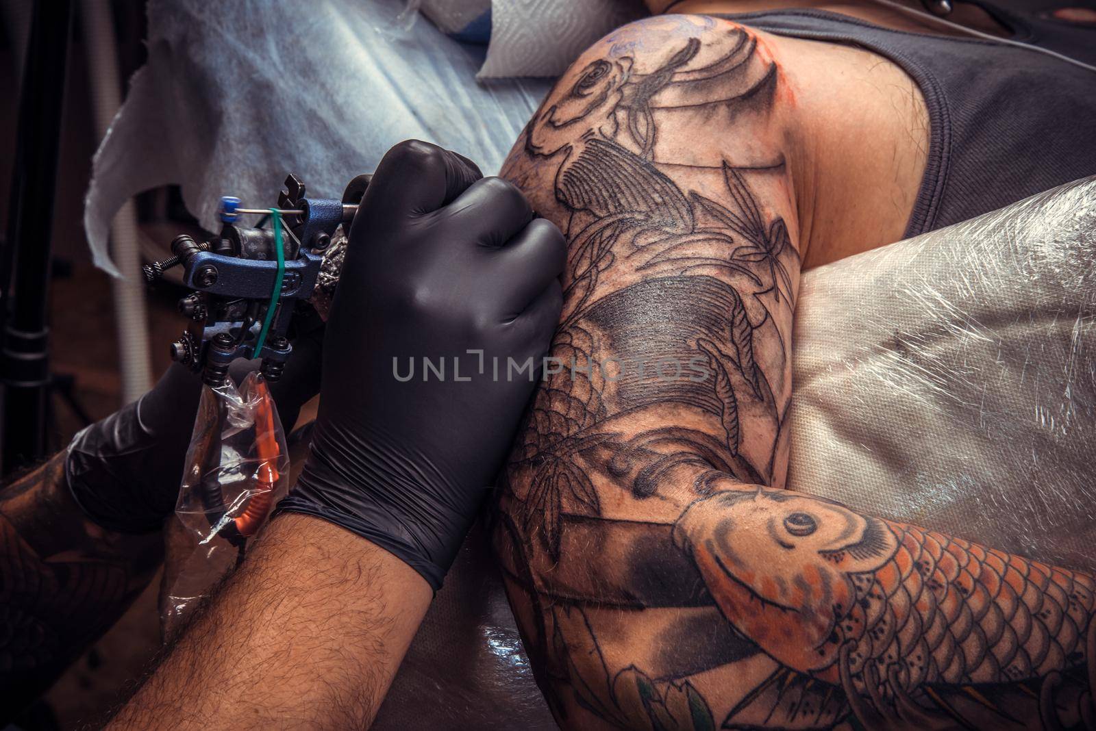 Professional tattooer works in tattoo parlor by Proff
