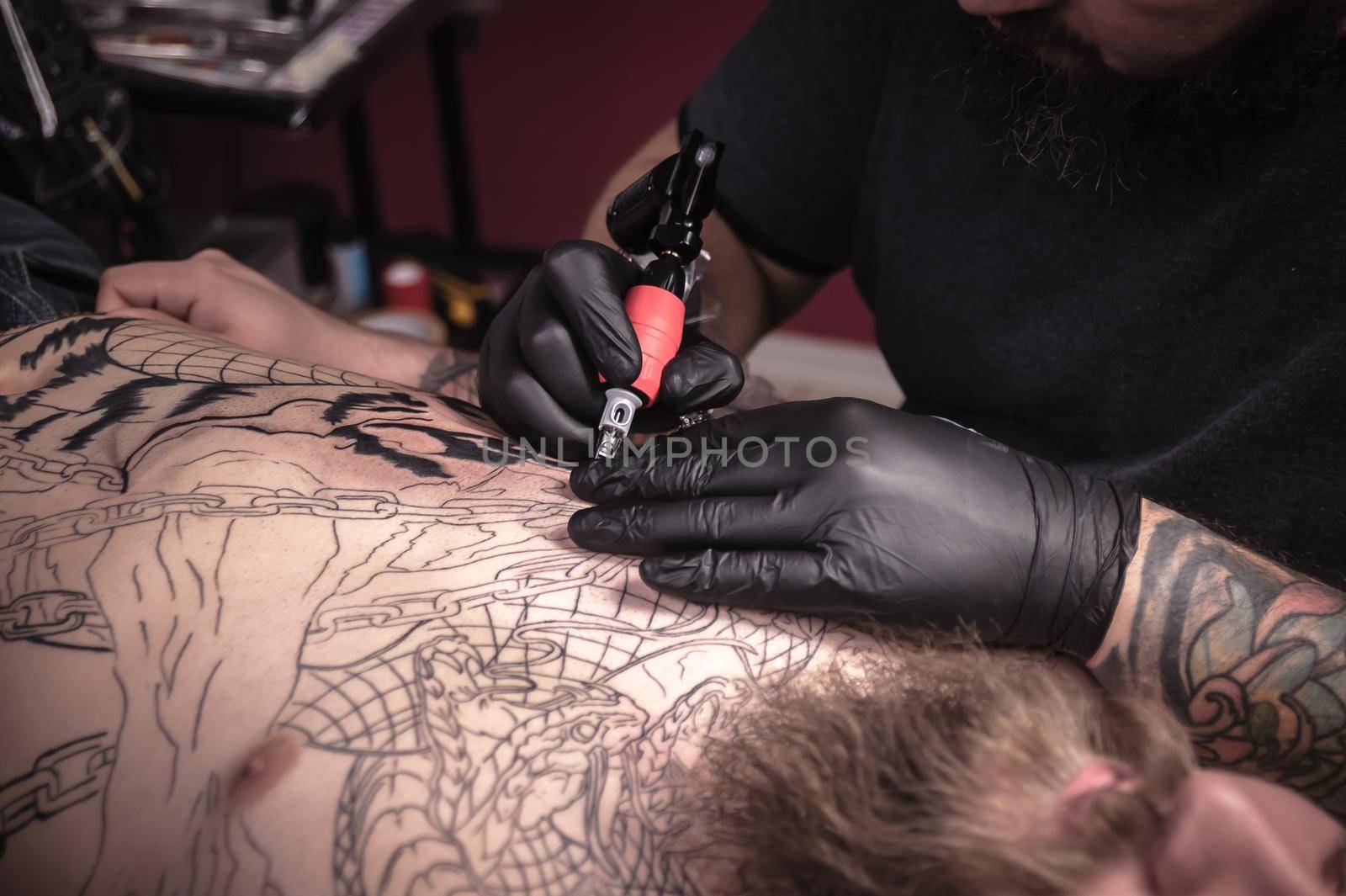 Tattoo specialist focused on his work in a workshop studio.