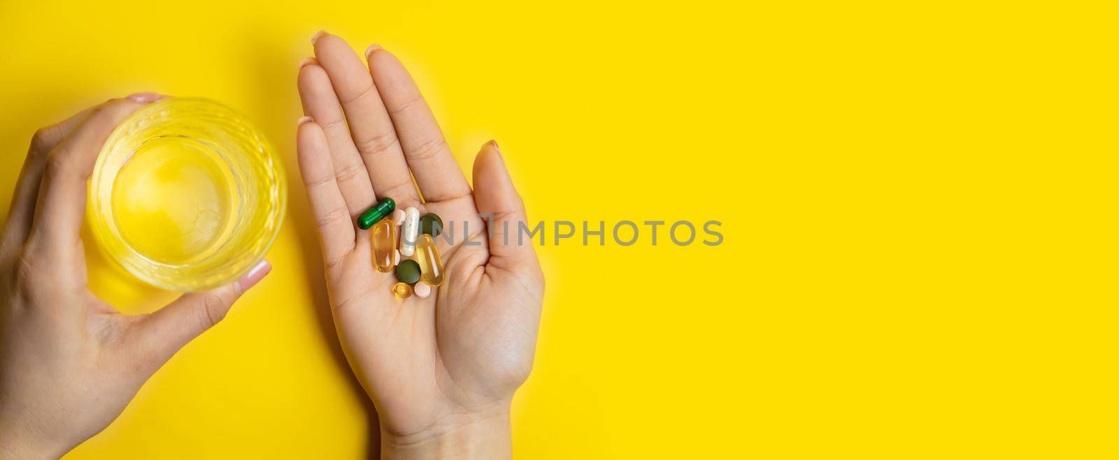 hands on yellow background, pills water cure virus.