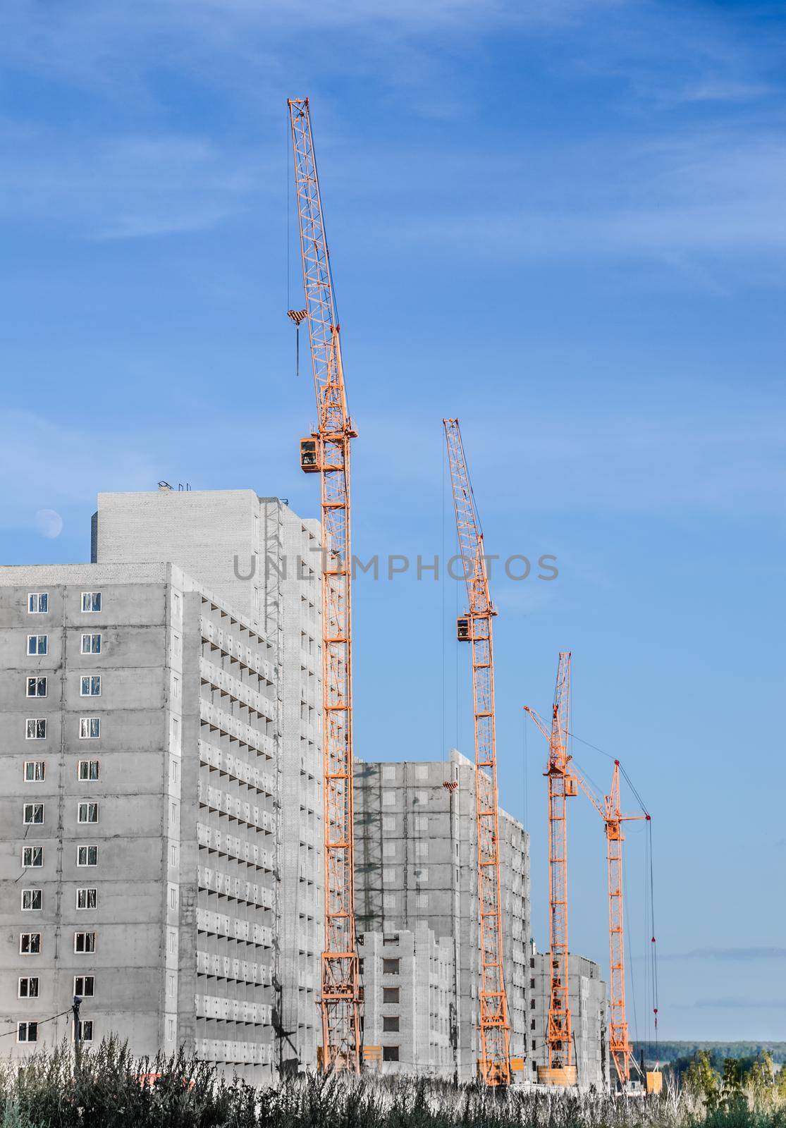 Building crane and building under construction against cloudy sky by Proff