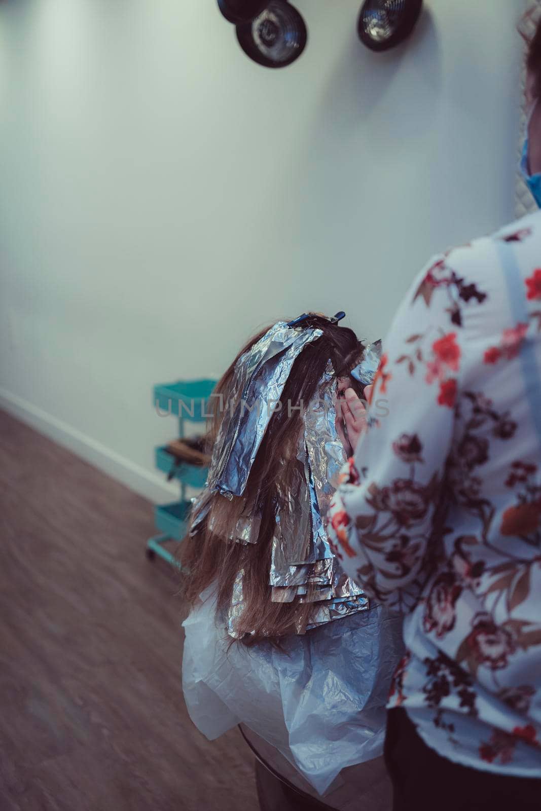 Woman dyes her hair in a barbershop, the process of dyeing her hair with foil. new