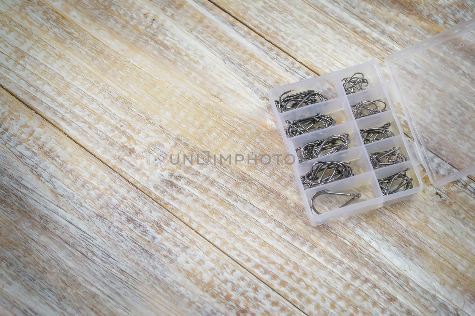 Fishing tackle, many colorful baits with a fishing rod on a wooden pier. Selective focus