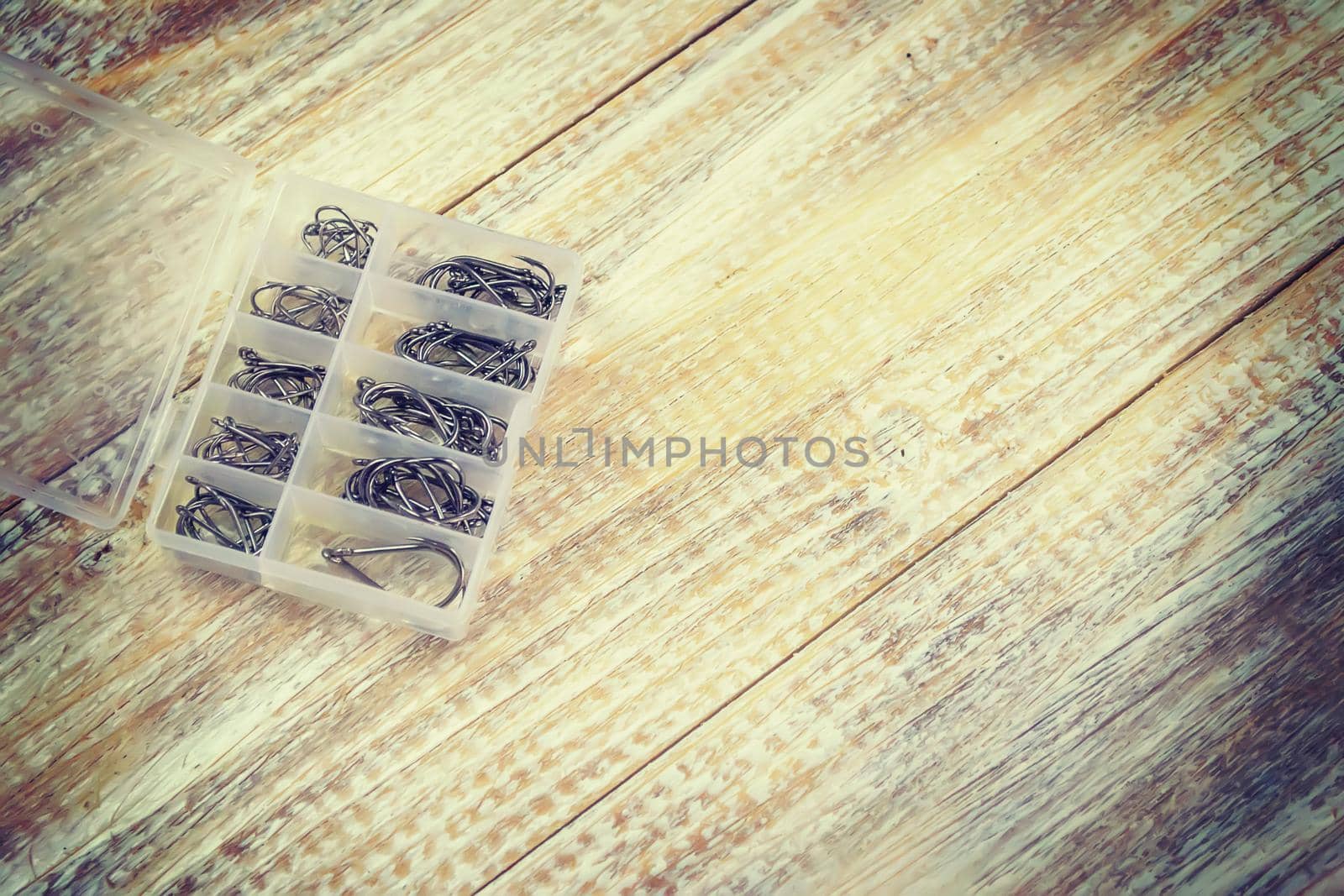 Fishing tackle, many colorful baits with a fishing rod on a wooden pier. Selective focus