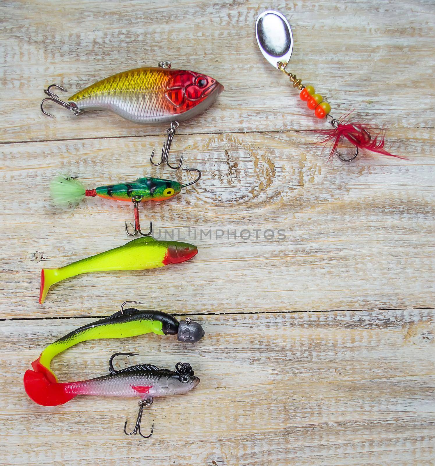 lot of colorful lures with the fishing rod on the wooden pier