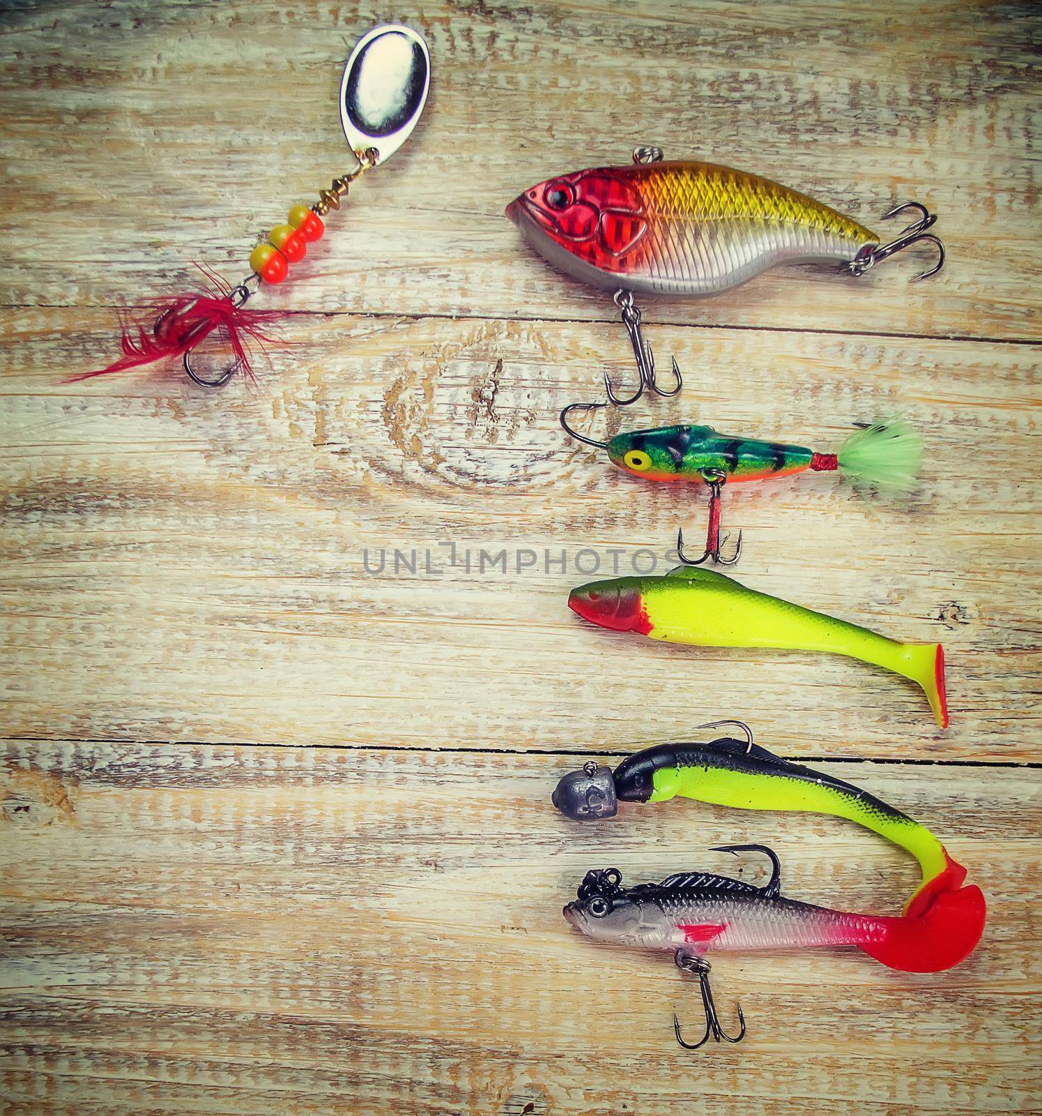 lot of colorful lures with the fishing rod on the wooden pier