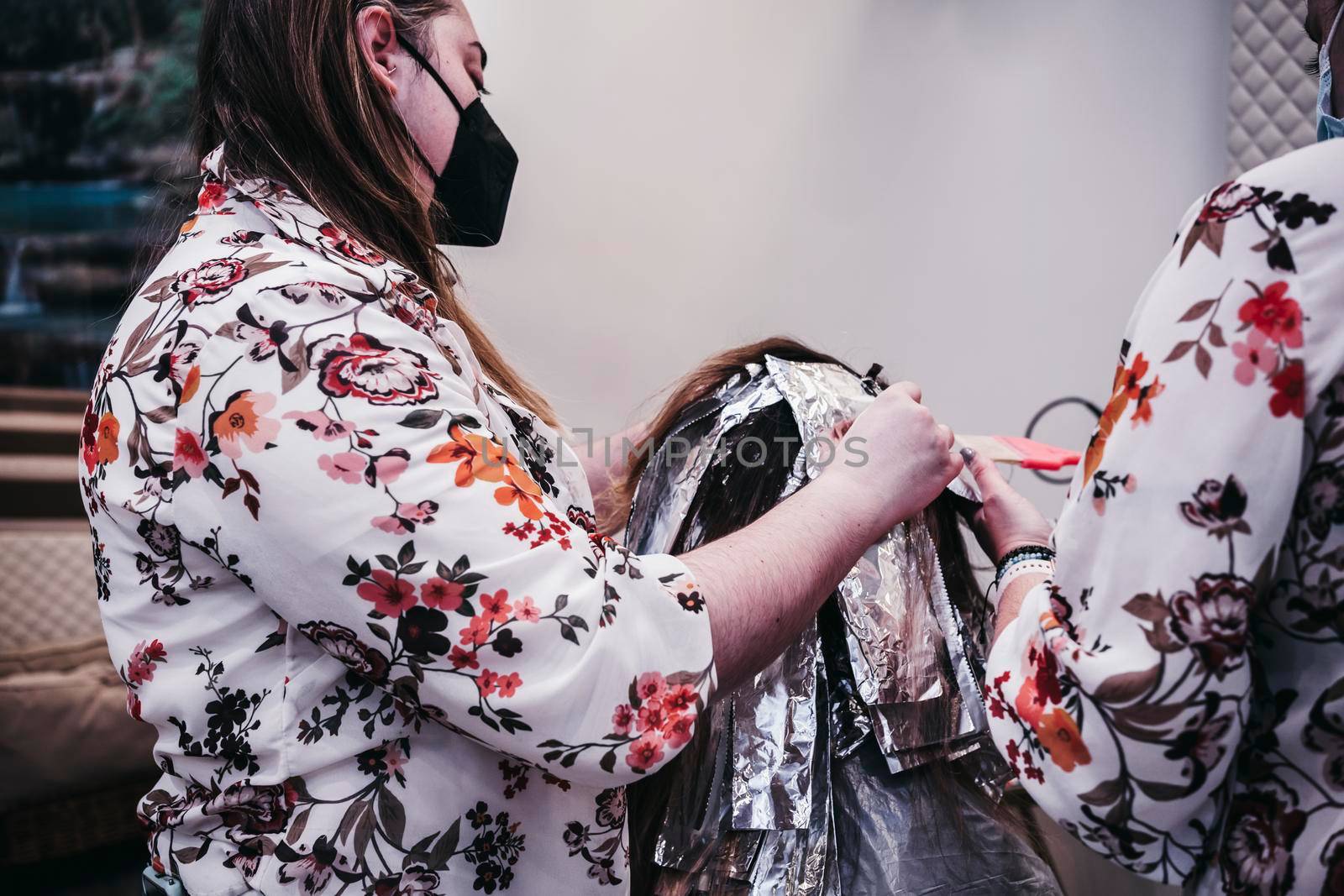 Woman dyes her hair in a barbershop, the process of dyeing her hair with foil. by barcielaphoto