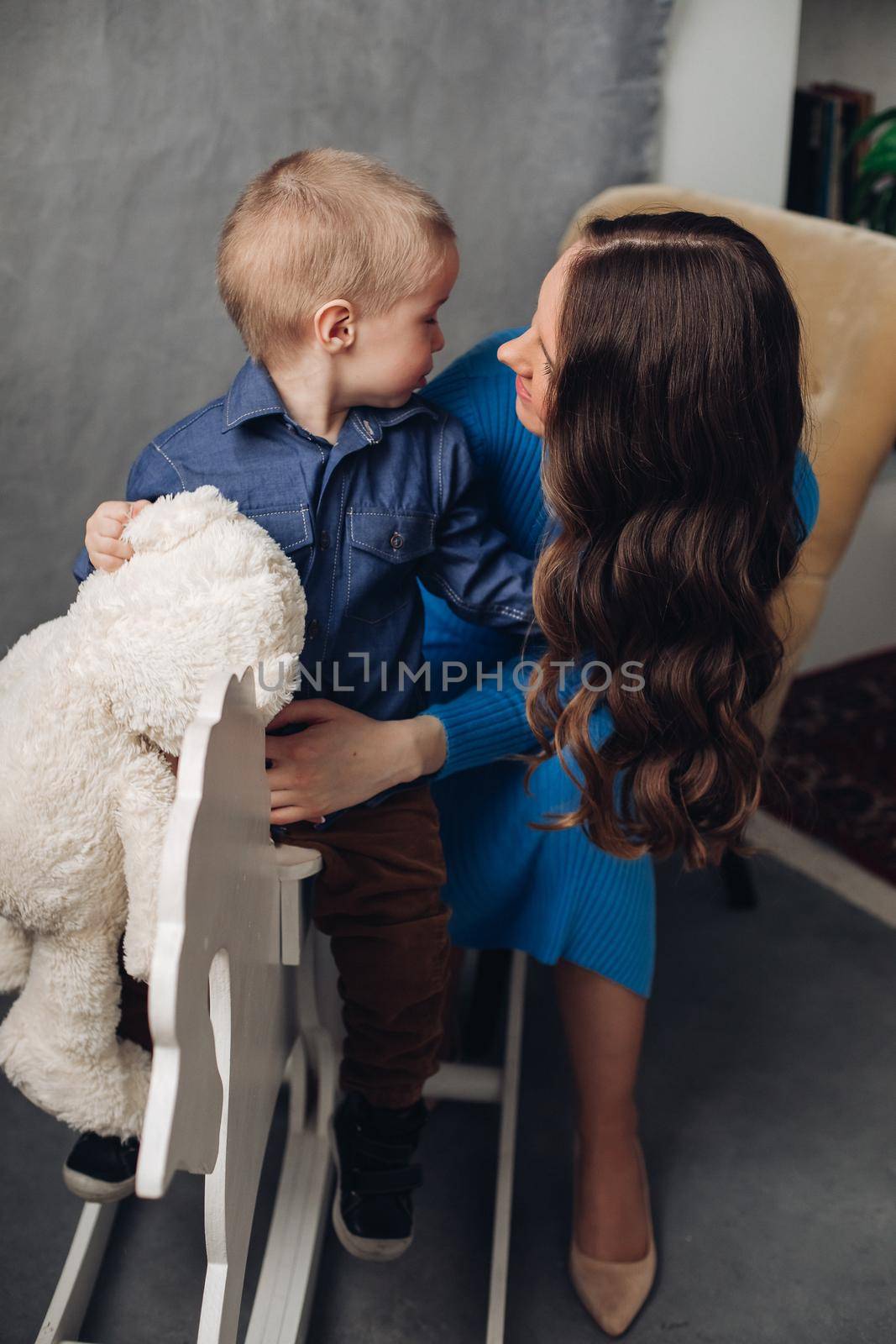 Laughing son and smiling mother in studio. by StudioLucky