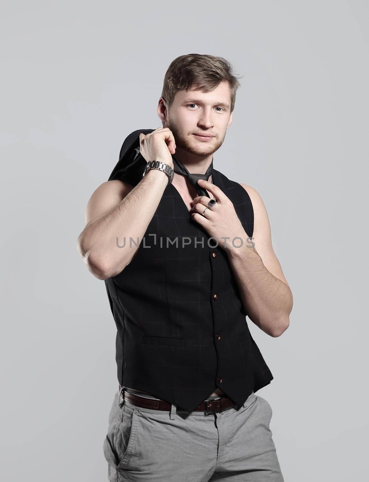 young businessman in a business suit without a shirt takes off his tie by SmartPhotoLab