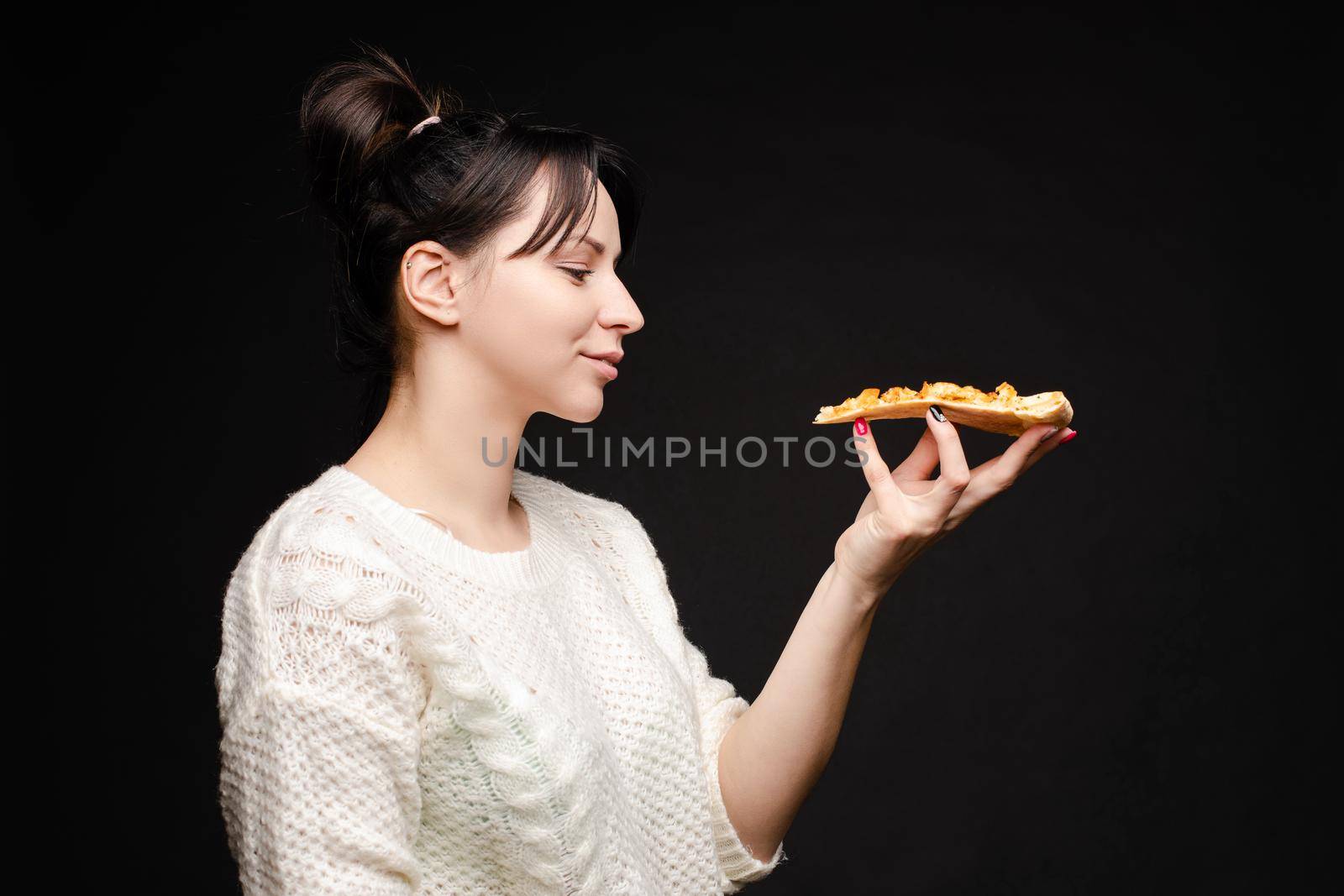 Young caucasian woman with tail eating piece of pizza. by StudioLucky