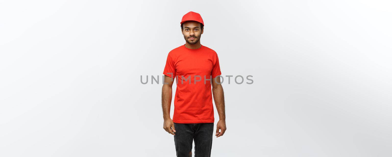 Delivery Concept - Handsome African American delivery man. Isolated on Grey studio Background. Copy Space