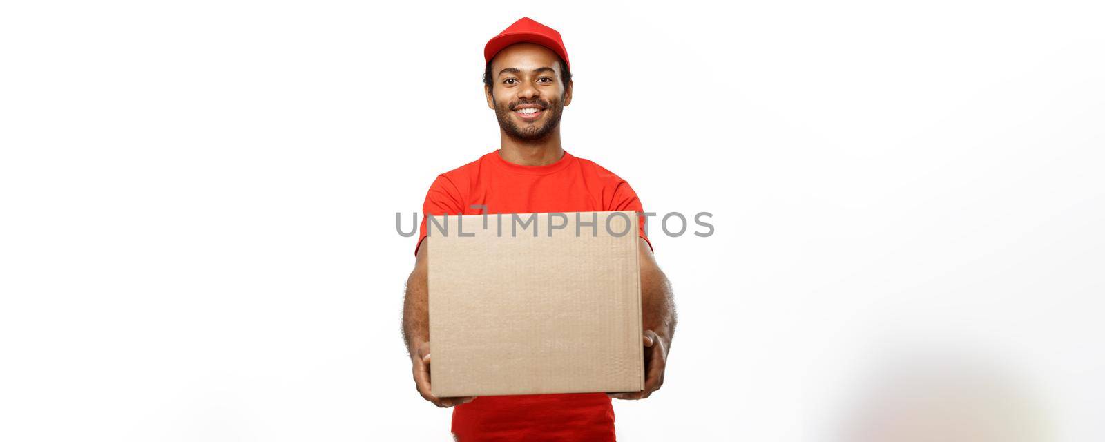 Delivery Concept - Portrait of Happy African American delivery man in red cloth holding a box package. Isolated on white studio Background. Copy Space.