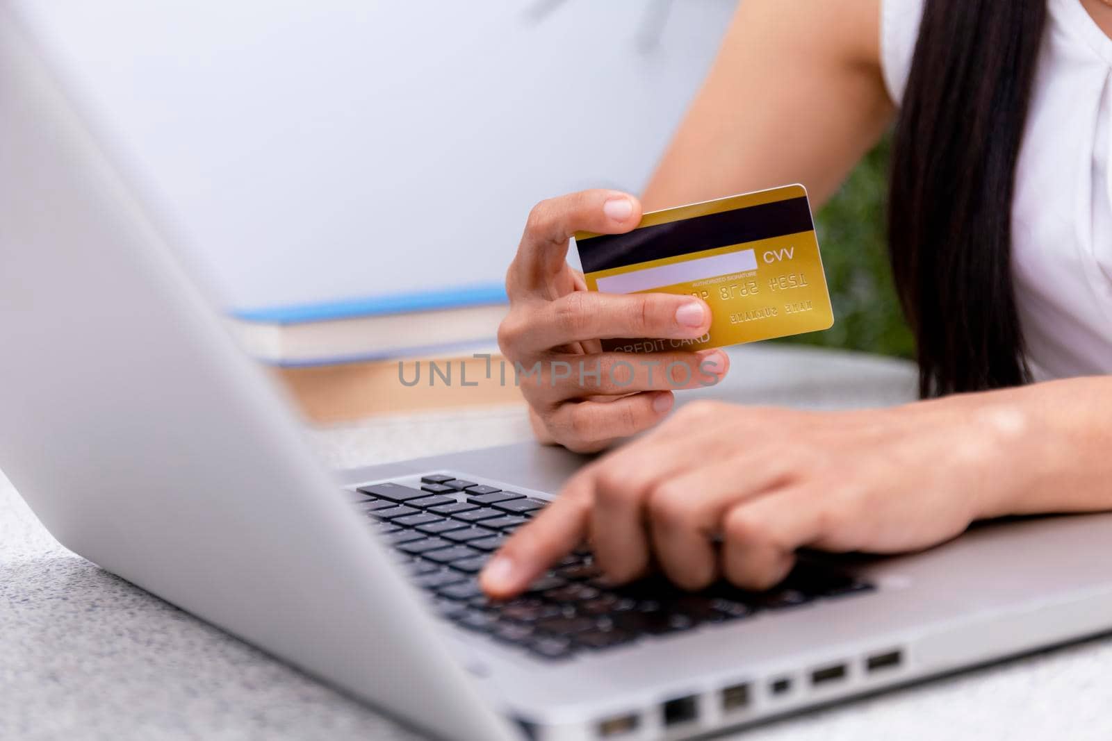 Young woman holding credit card and using laptop computer. Women working at home. Online shopping, e-commerce, internet banking, spending money, working from home concept. Technology shopping online concept.