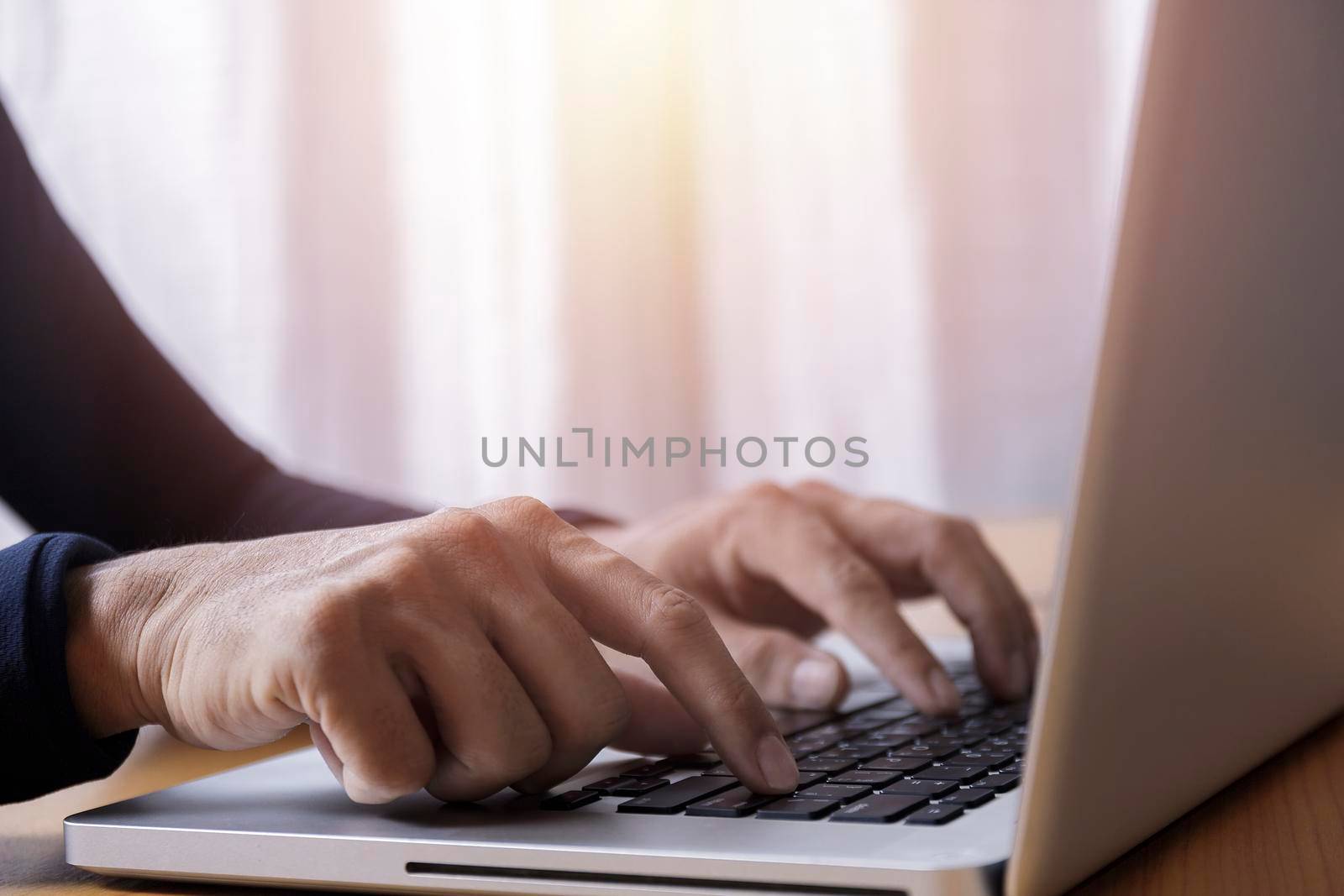 Close up businessman using laptop computer at home. Close up male hands typing on laptop keyboard in office. Man hands using laptop keyboard. Close-ups of technology in use concept.