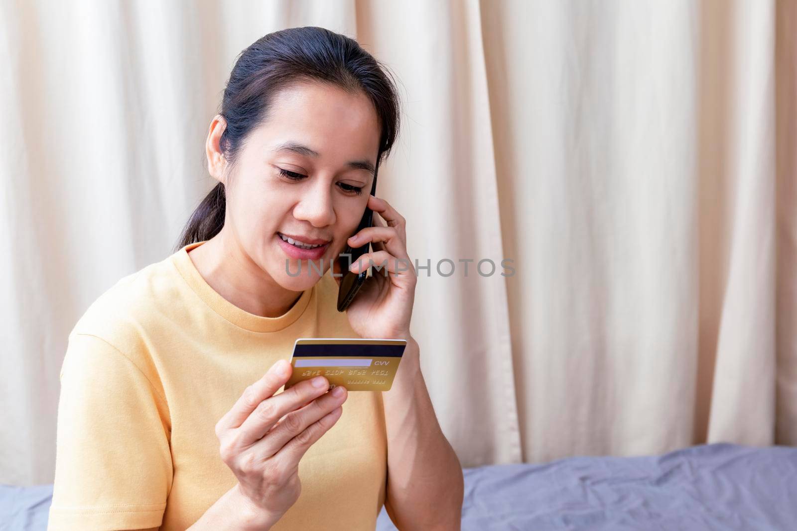 Happy asian women use smart phone and creadit card speak to pay shopping online. Women use smartphone order shopping online and pay with creadit card. stay home covid-19 online shopping concept. by Satrinekarn