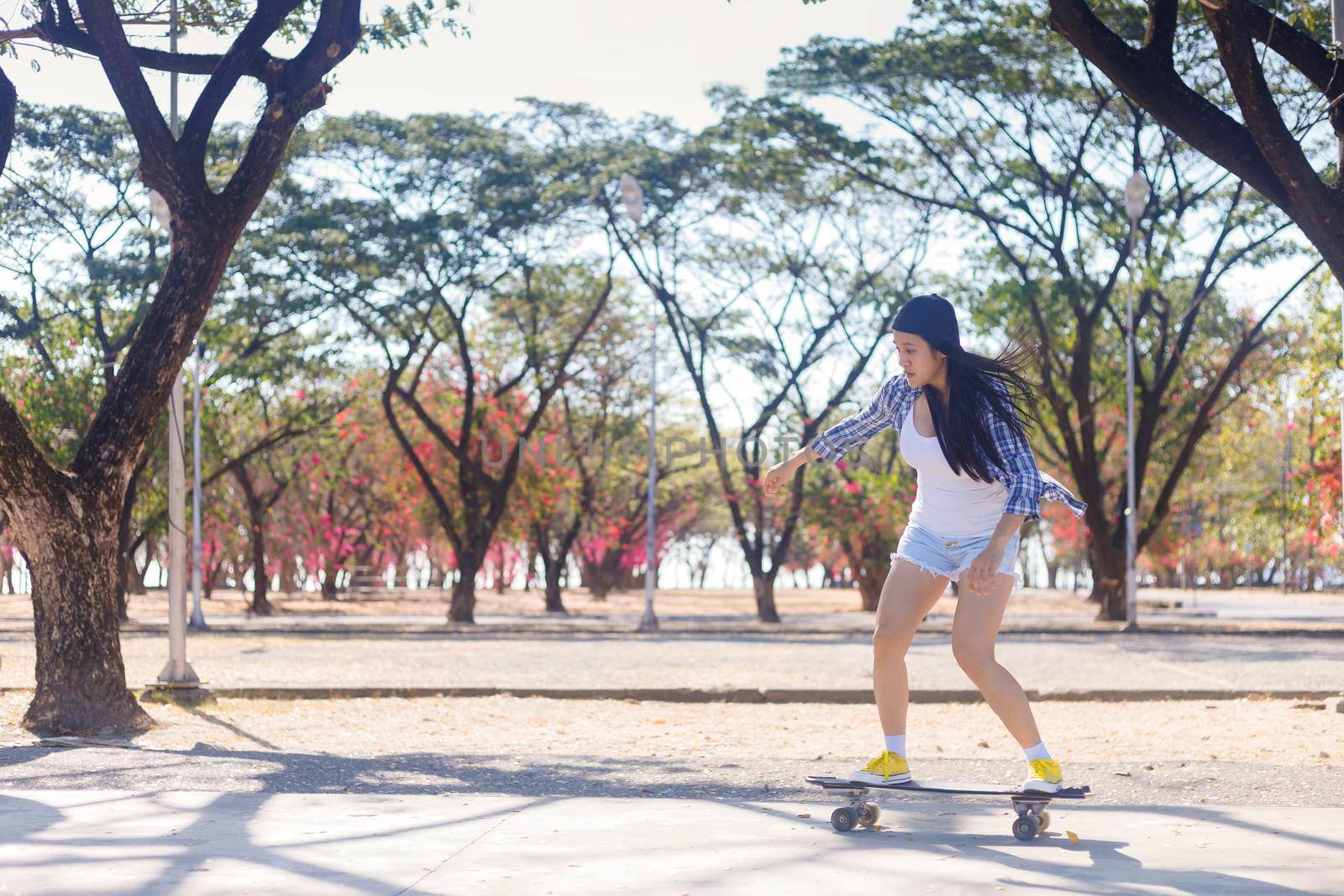 Young asian women play surf skate board at park skate ramp outdoors on morning. Happy women play surfskate board at park . Sport activity lifestyle concept