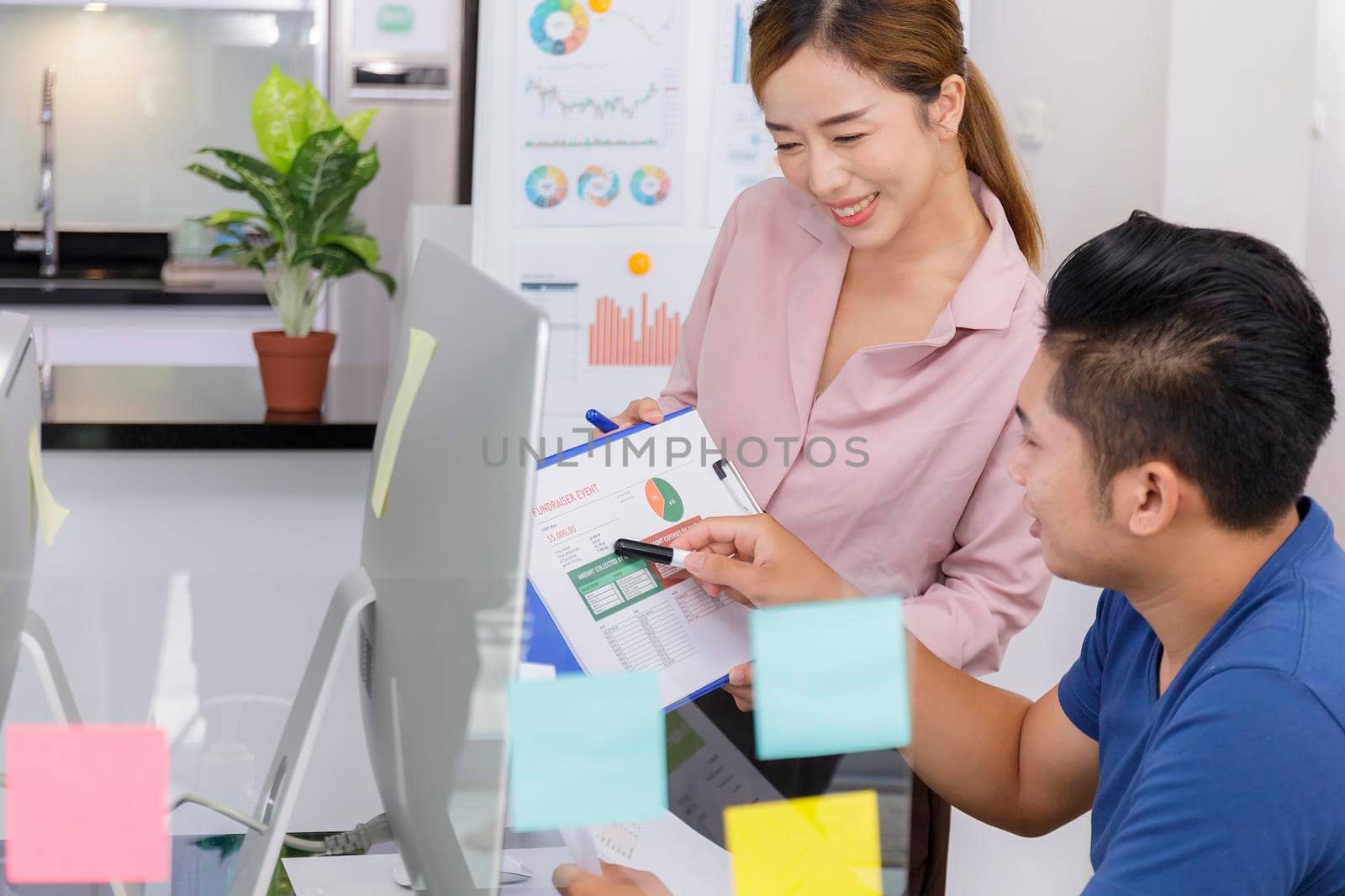 Asian small business start up working at Private Home Office social distancing among Coronavirus outbreak. Business people show and talking about document chart financial report.