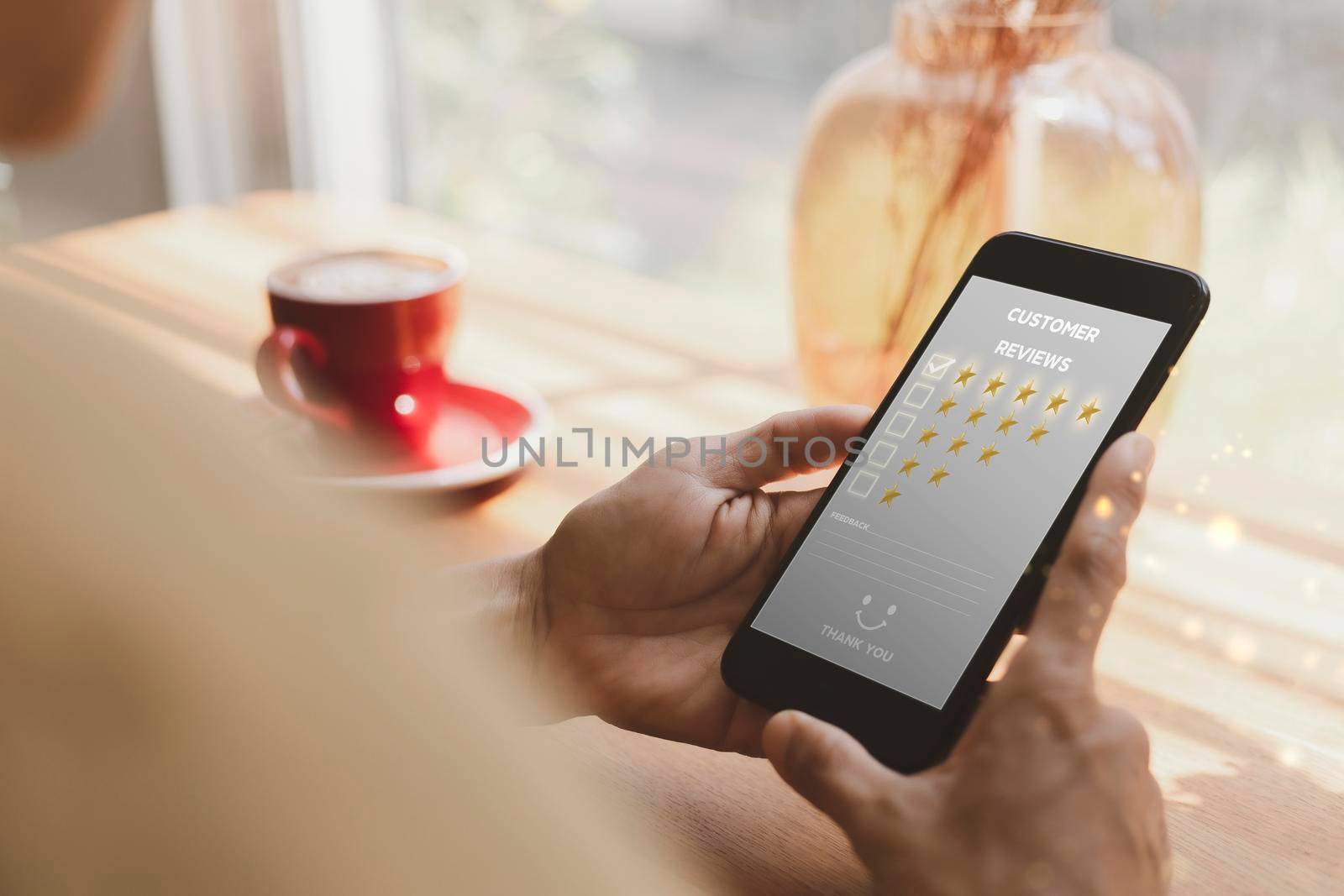 Customer service and Satisfaction concept ,Women hand hold smart phone choose the 5 star icon to give satisfaction in service. rating very impressed in coffeeshop.