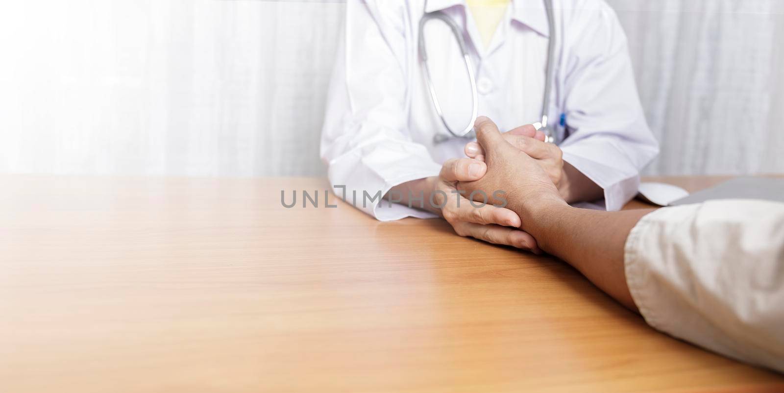 Doctor working in her clinic and listening to the patient, Doctor hold hand of patient and listening explaining his symptoms. healtcare and assistance concept