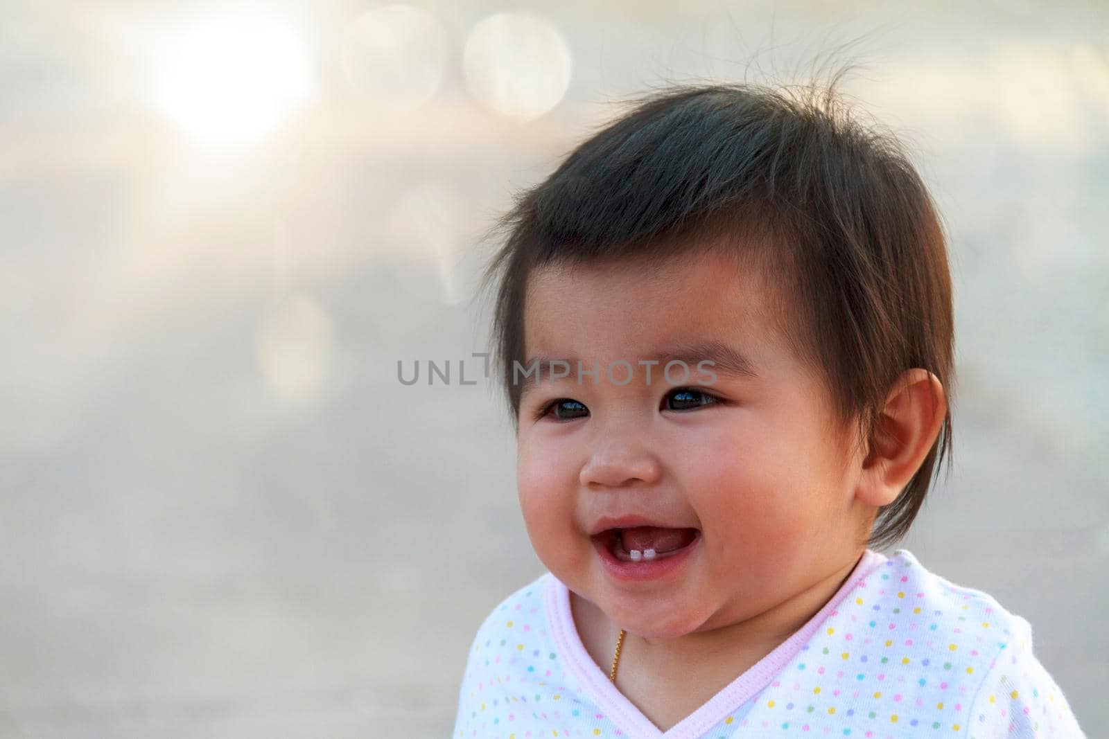 Close up portrait little girl. Cute adorable asian little girl play in park with sun ray background. Happy baby girl play in outdoor park. Close up and soft focus baby gril.