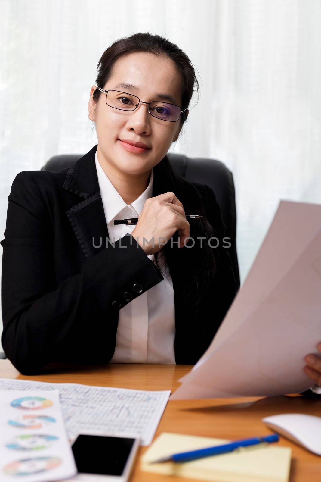 Business women smileing wear glasses holding document paper chart sitting at office. business people using computer PC  at office. Business at home concept.