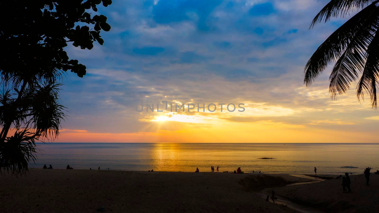 Silhouettes of group of people during the sunset in Seaside beach. Beautiful sunset over the sea with silhouettes happy group of people relax. Holiday and summer concept