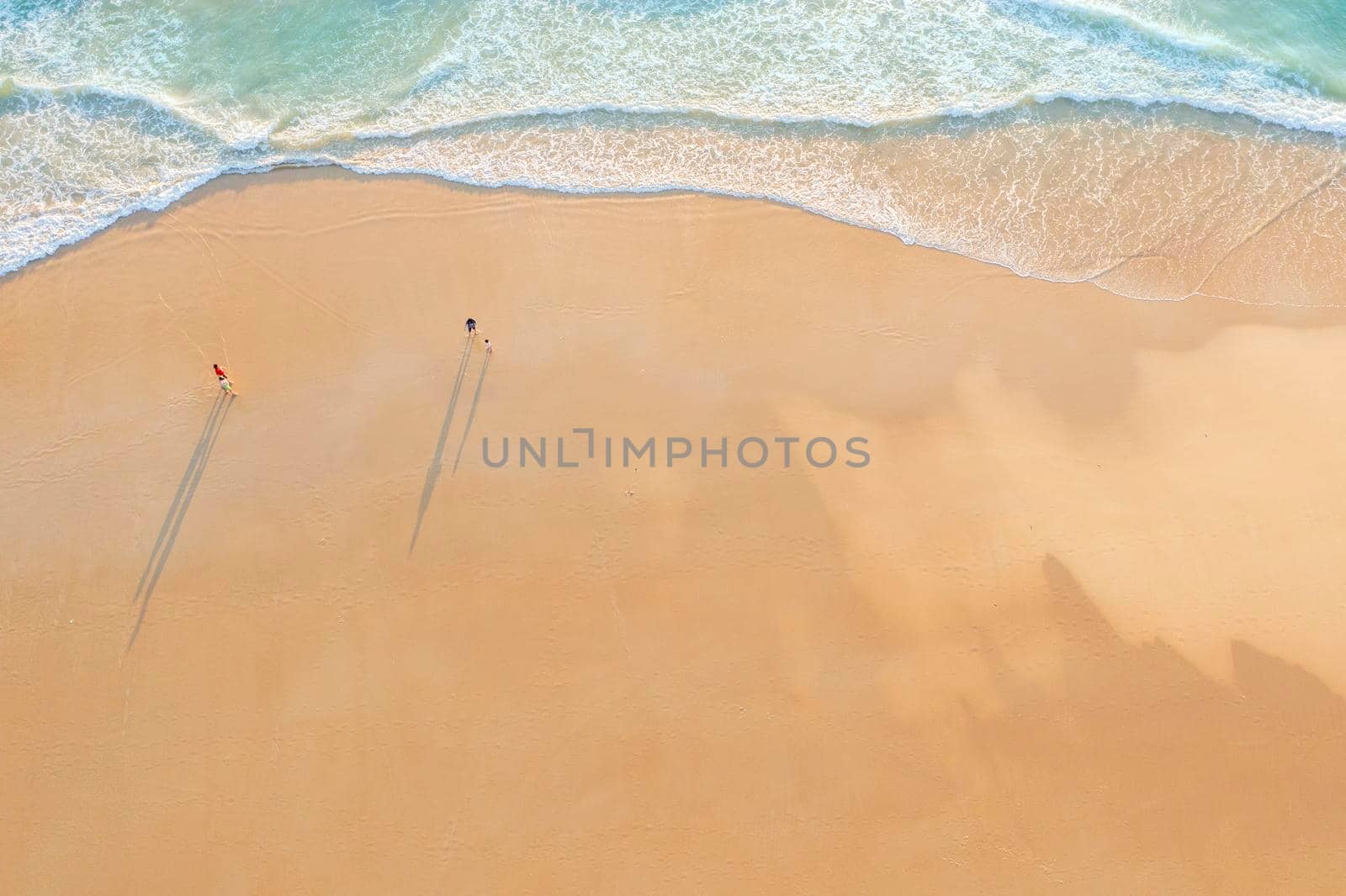 Aerial drone top view crowd of happy people relax at tropical Beach with sunset in Phuket, Thailand, Beautiful Phuket beach is famous tourist destination at Andaman sea. Holiday summer concept