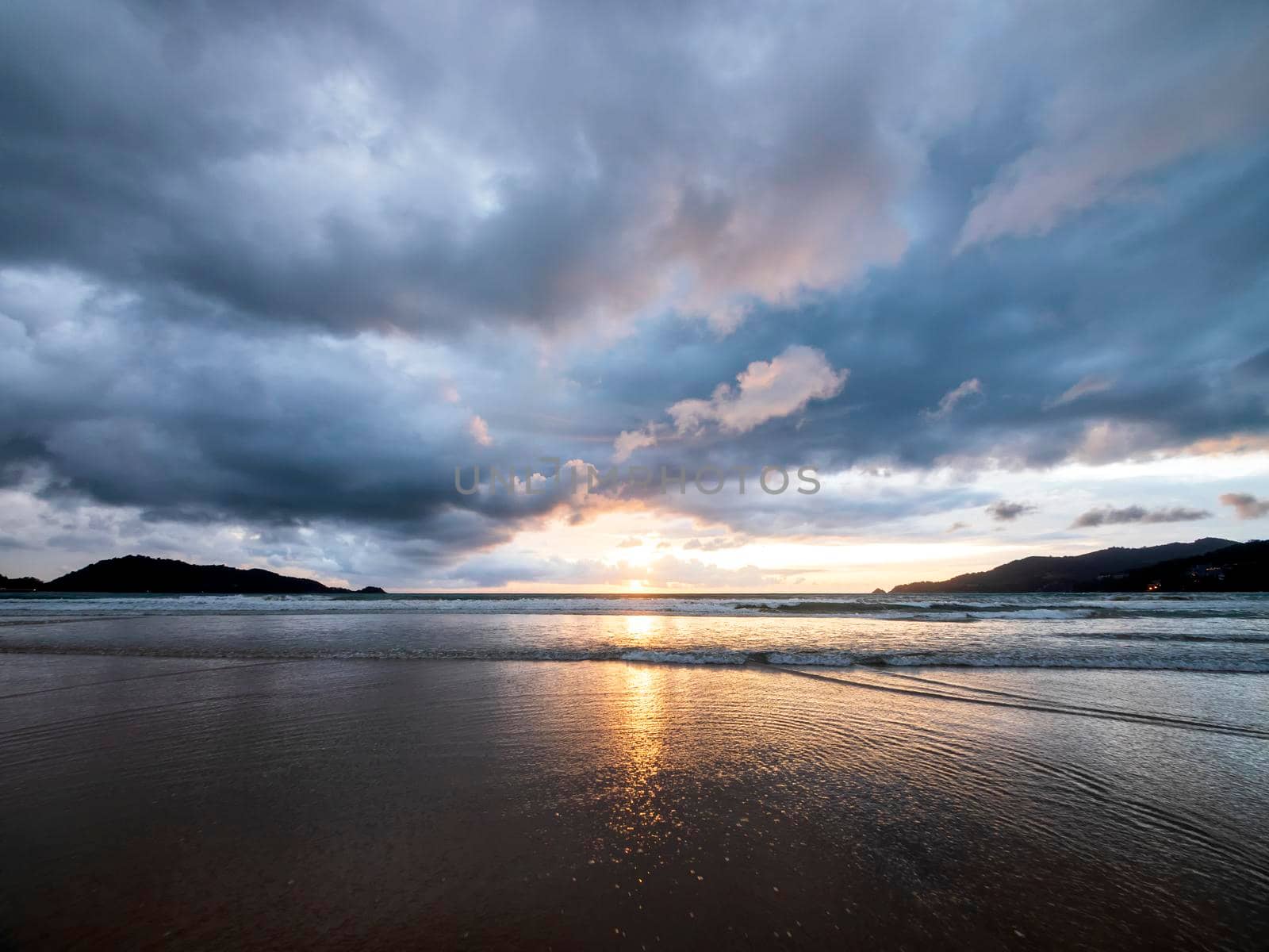 Beautiful sunset over the calm sea with cloud and sky background. Sunset over tropical beach. Nature summer  concept. Peak sunset over sea with yellow light reflect in cloud