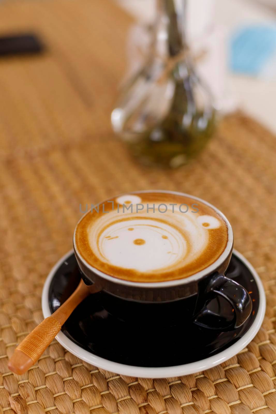 Close up hot cappuccino, latte, caramel macchiato on table with blur coffee shop background. Process with warm vintage tone style. 