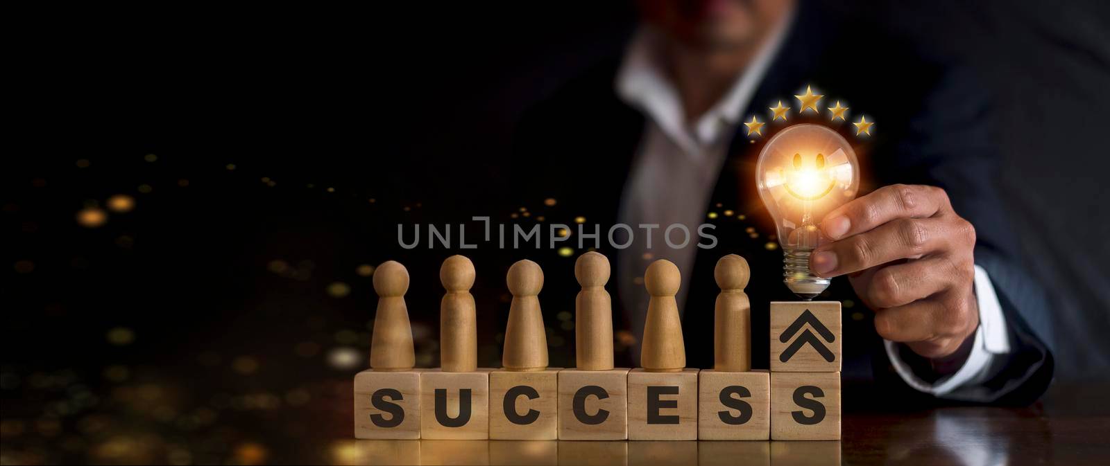 business man hand holding light bulb on wood block with Word success, business teamwork concept with innovation and inspiration, innovative technology in science and communication concept.