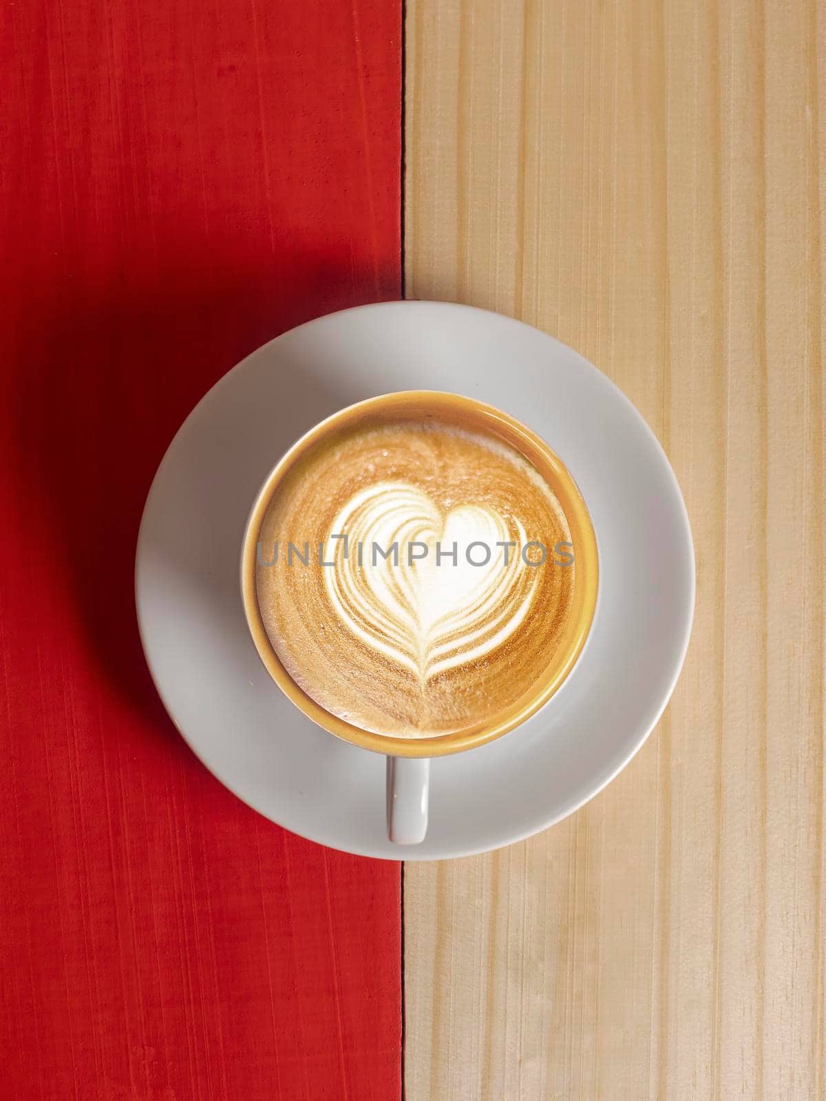 Coffee Mug on Wooden Table. Top view cup of coffee on wooden table. Close up hot coffe in white cup on wood table. Coffee latte art heart shapes in white cup on wood table.
