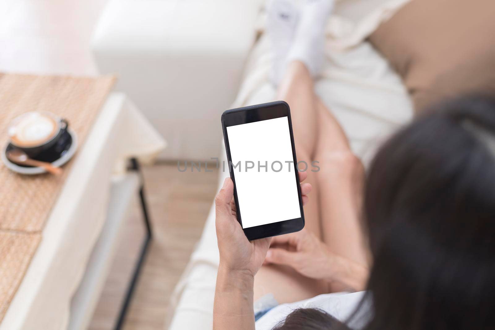 Close up hands of woman using mobile phone, cell phone in coffee shop. Hands of women holding blank empty screen smart phone in cafe. Women relax with mobile phone sit in restaurant