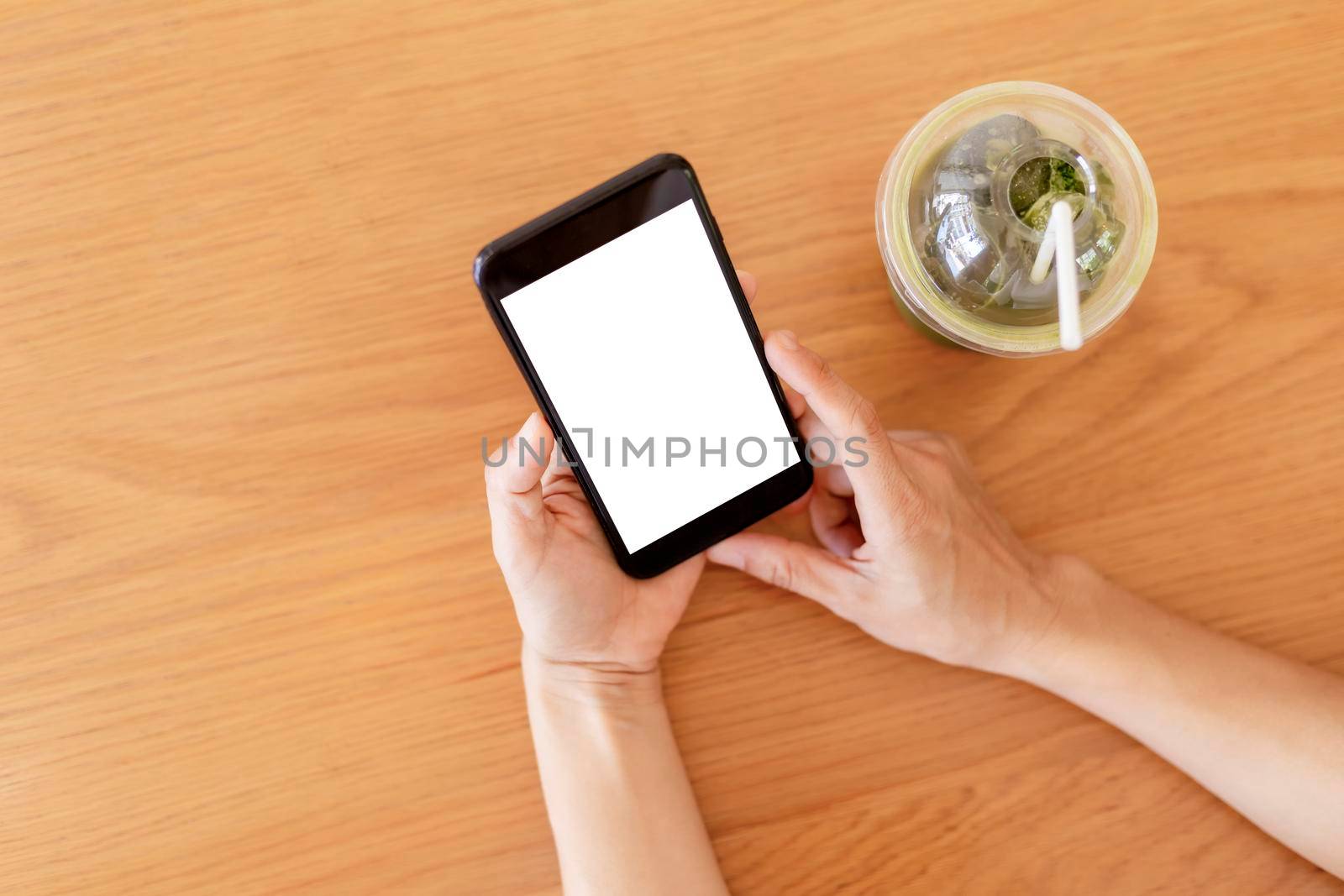 Close up hands of woman using mobile phone, cell phone in coffee shop. Hands of women holding blank empty screen smart phone in cafe. Women relax with mobile phone sit in restaurant