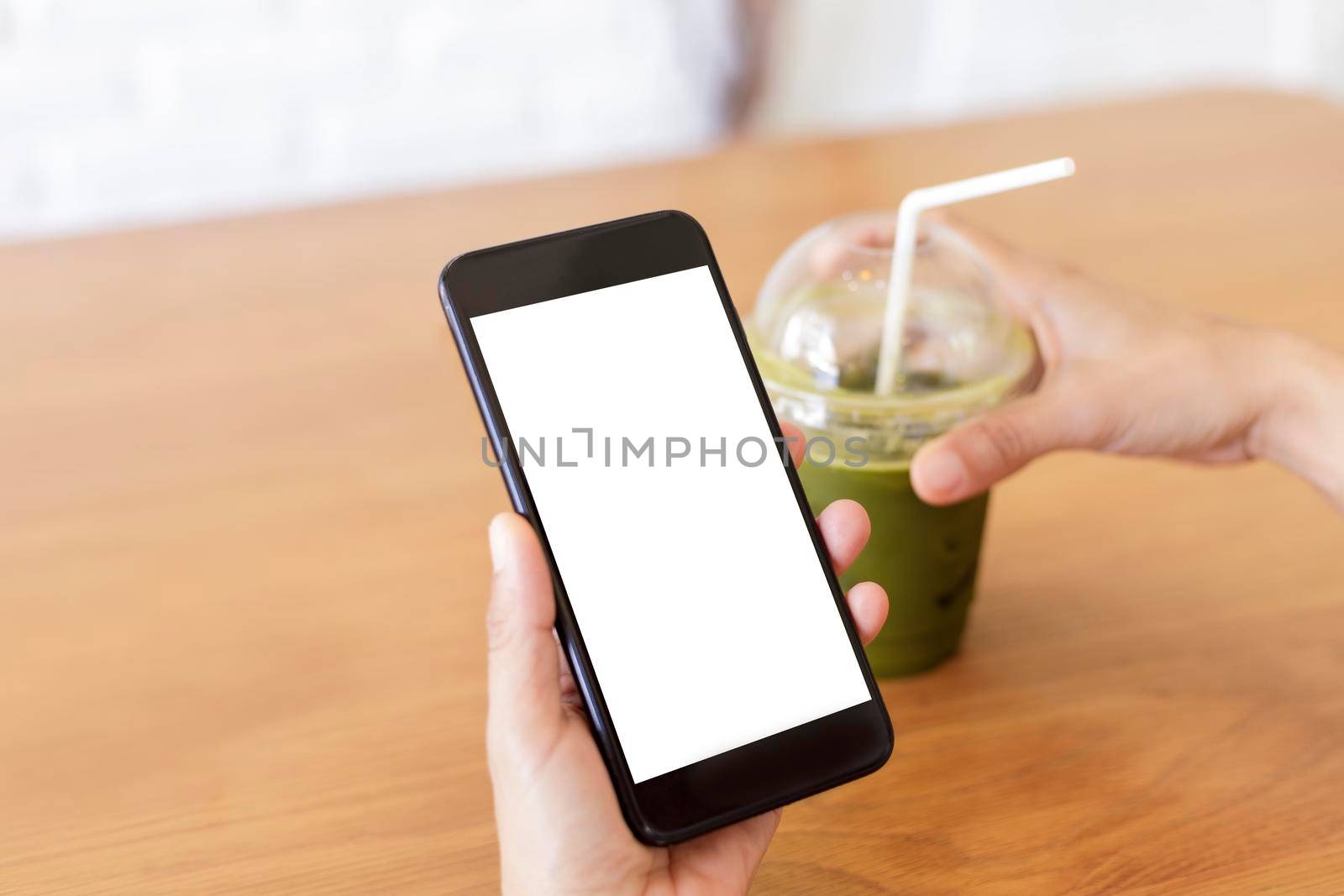 Close up hands of woman using mobile phone, cell phone in coffee shop. Hands of women holding blank empty screen smart phone in cafe. Women relax with mobile phone sit in restaurant
