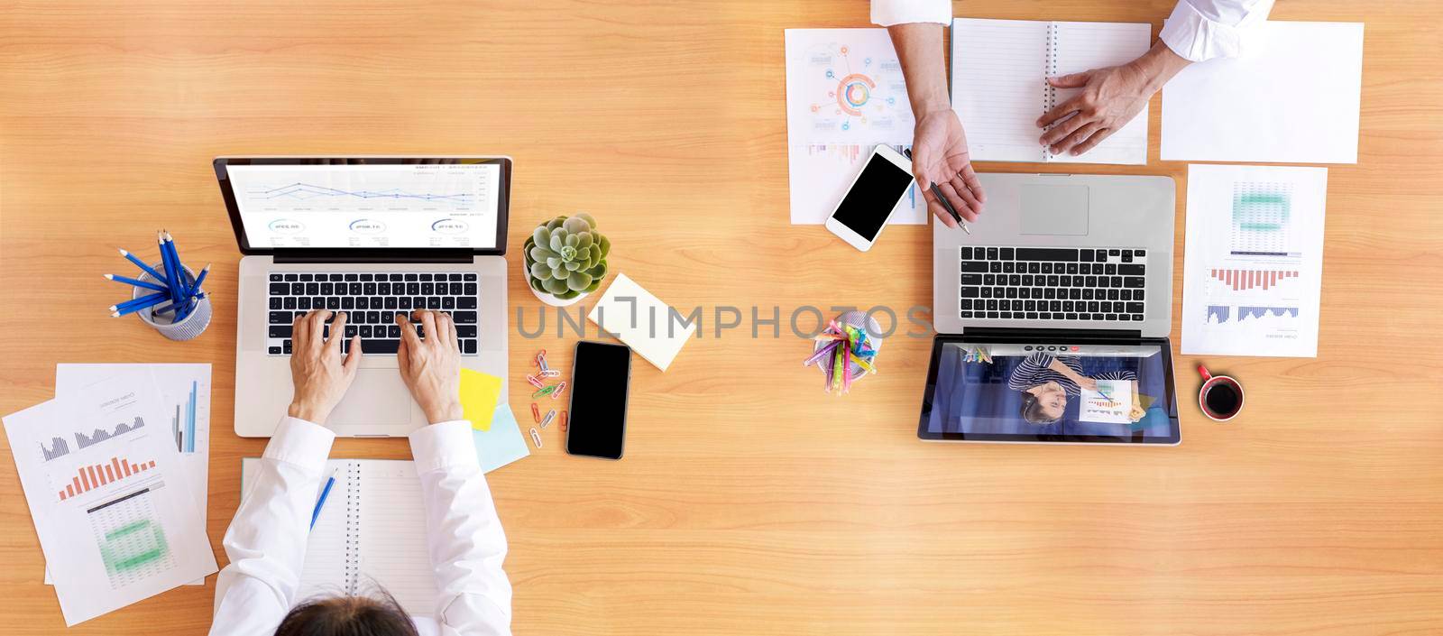 Top view Businessman and businesswoman analysis financial chart with videoconference online meeting. Business people using laptop meeting with diverse colleagues. Covid-19 working from home.