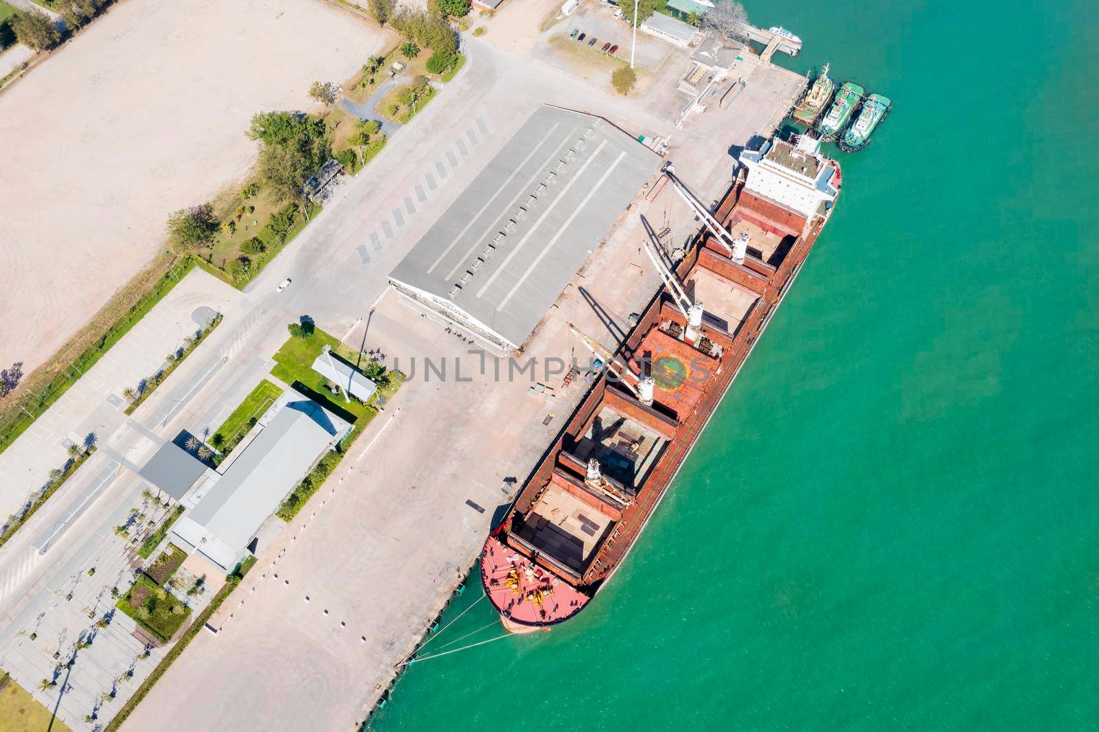 Aerial drone top view of containers cargo ship at industrial import-export port. Business logistic import and export freight transportation by container ship in open sea