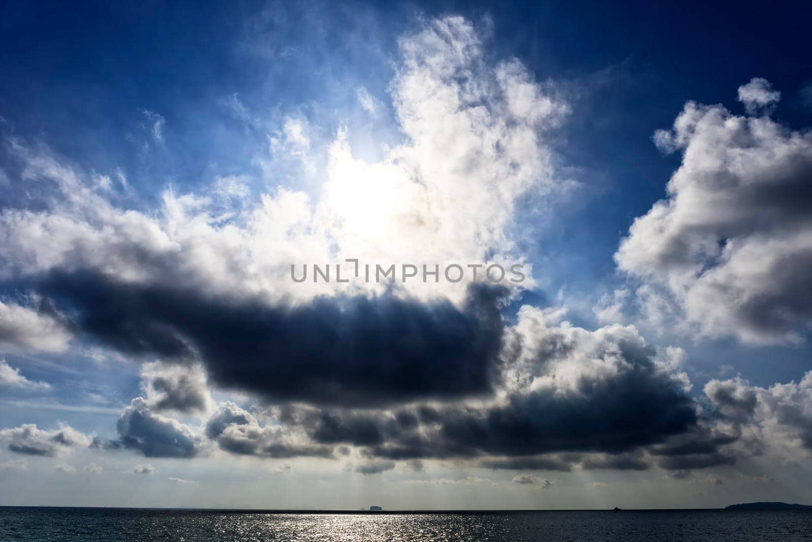 Bright sunlight over sea, beautiful shine sun beam in sky. Cloud sky with sun ray over the sea.