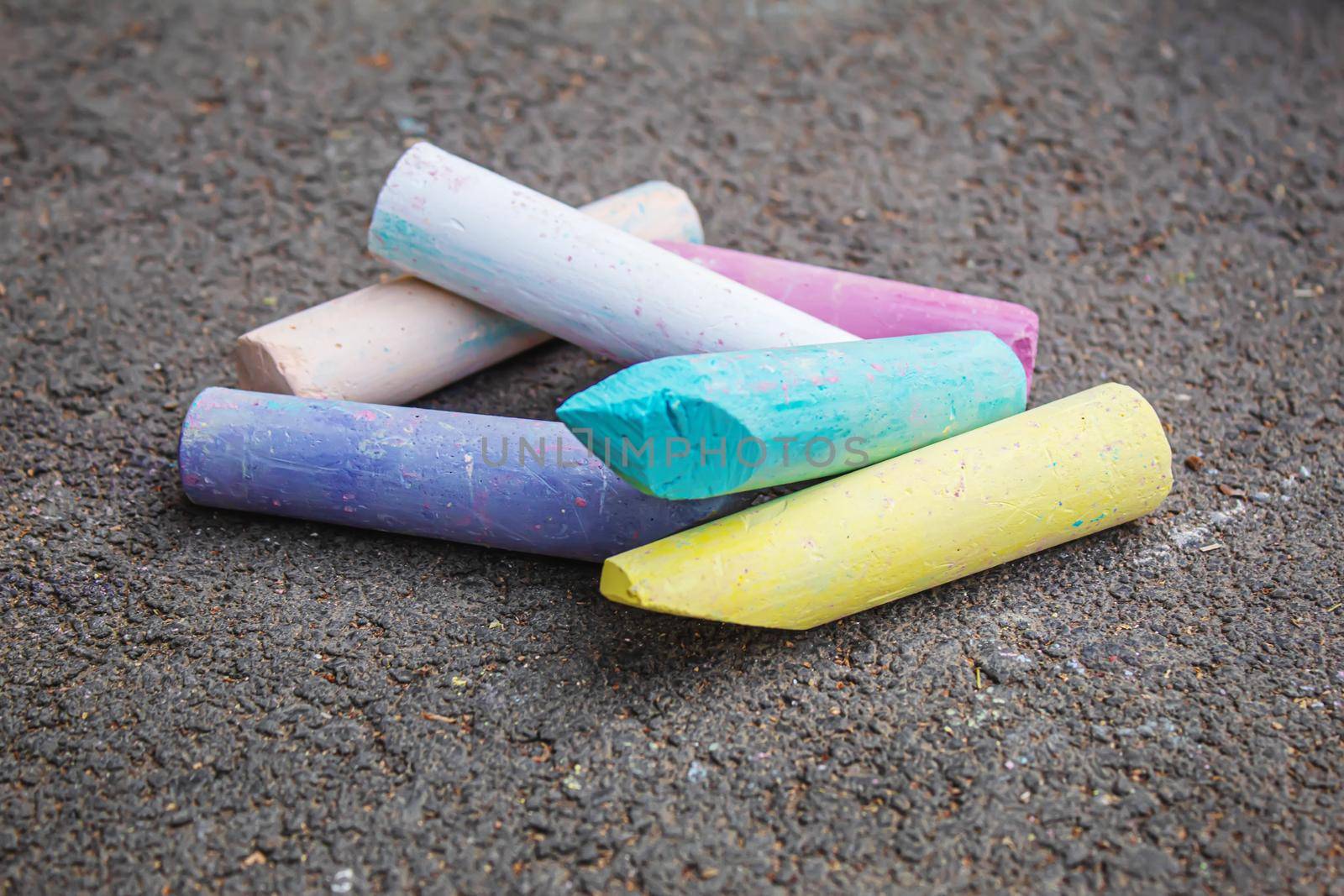 Three colored stripes, drawing with chalk on asphalt. Selective focus by mila1784