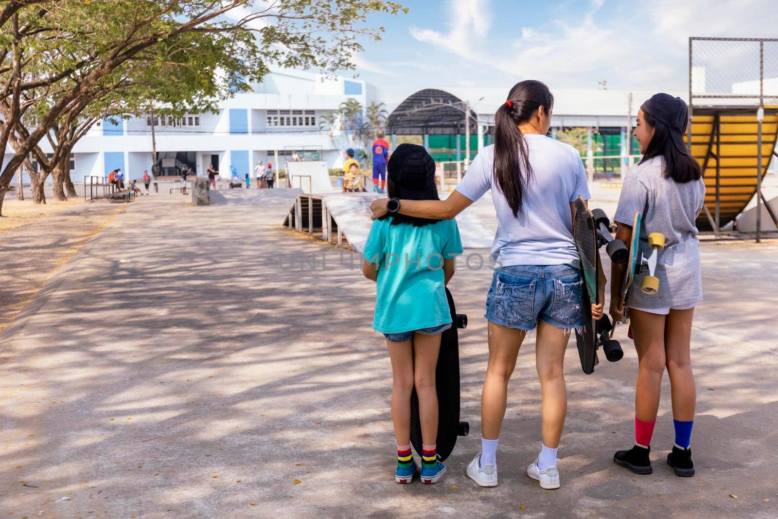 Two little girl hand hold skateboard, surf skate on public skate ramp park background. Free relax skateboard surf skate trendy concept. Fashion portrait of female hands holding surf skateboard