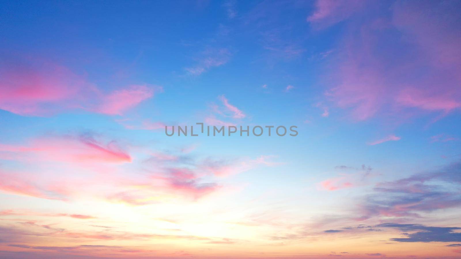 defaultBeautiful morning clear sky background. Colorful yellow blue sky. Morning colorful clear blue sky background with soft white clouds sunrise or sunset.