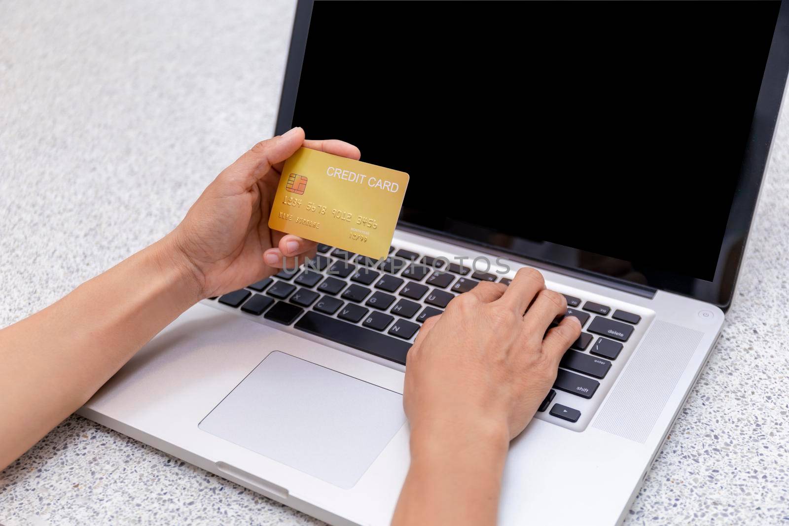 Young woman holding credit card and using laptop computer. Women working at home. Online shopping, e-commerce, internet banking, spending money, working from home concept. Technology shopping online concept. by Satrinekarn