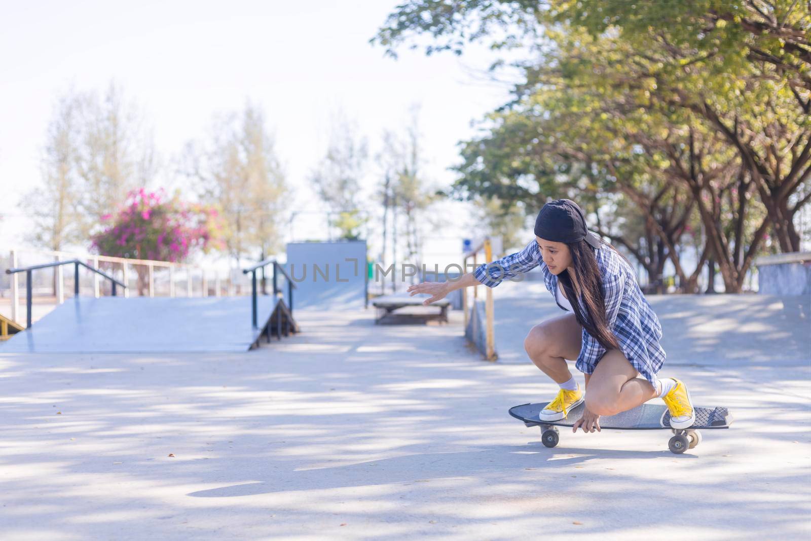 Young asian women play surf skate board at park skate ramp outdoors on morning. Happy women play surfskate board at park . Sport activity lifestyle concept