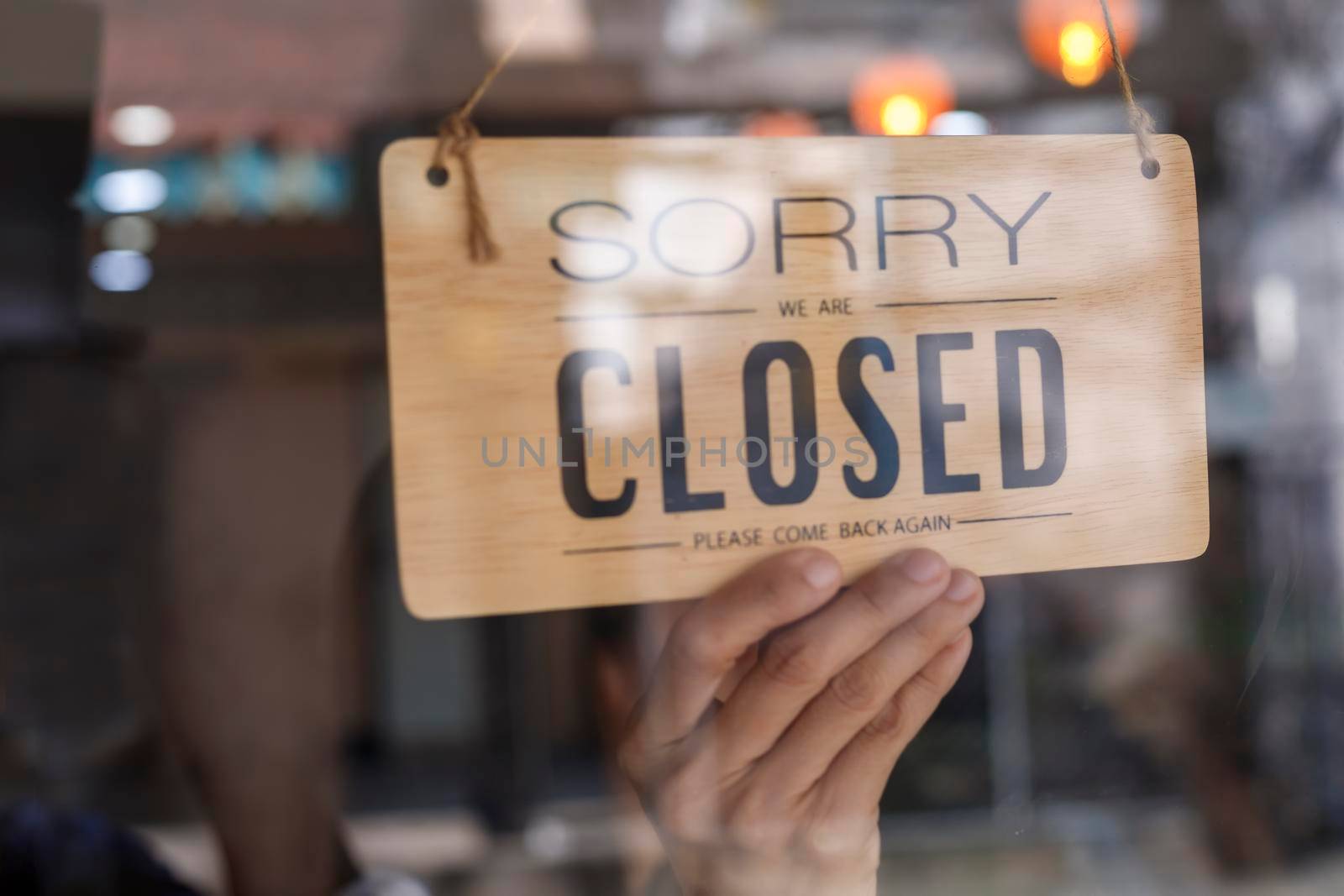 Hand of asian owner retail ,coffee shop woman turning sign board to closed. Protection to pandemic of coronavirus. Close store,restaurant or pub due to lockdown quarantine of covid-19.