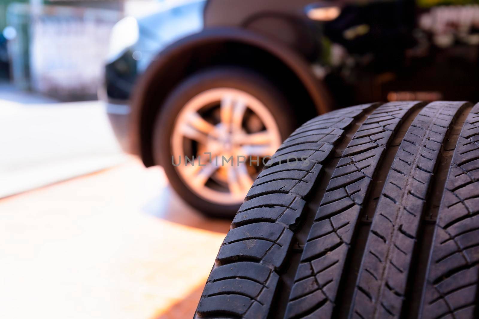 Close up of old tire with car wheel background. Tire workshop and change old wheel on the car. Used car tires stacked in piles at tire fitting service repair shop