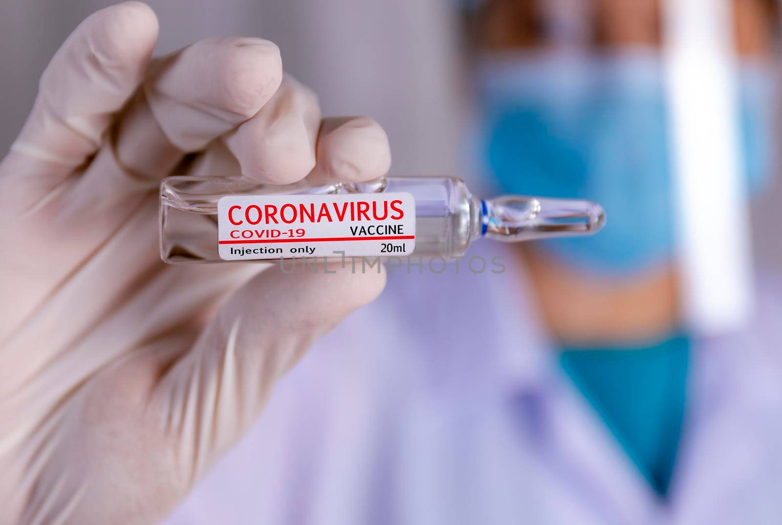 Covid-19 coronavirus vaccine. Close up hands of scientist show Covid-19 vaccine in glass vial. Hands of doctor wear latex glove holding Covid-19 vaccine in glass vial. Healthcare and medical concept.