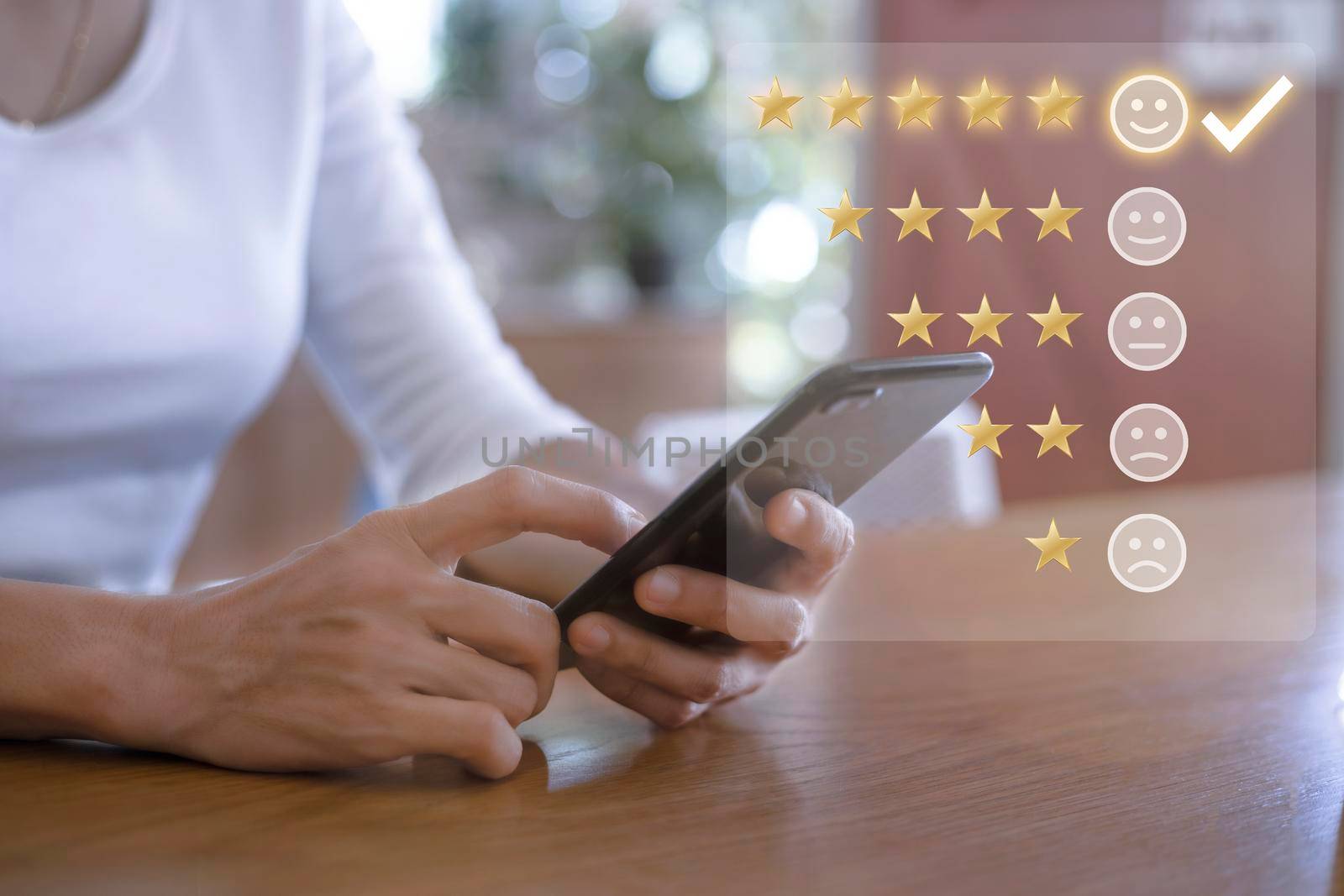 Customer service and Satisfaction concept ,Women hand hold smart phone empty screen choose the 5 star icon to give satisfaction in service. rating very impressed in coffeeshop.