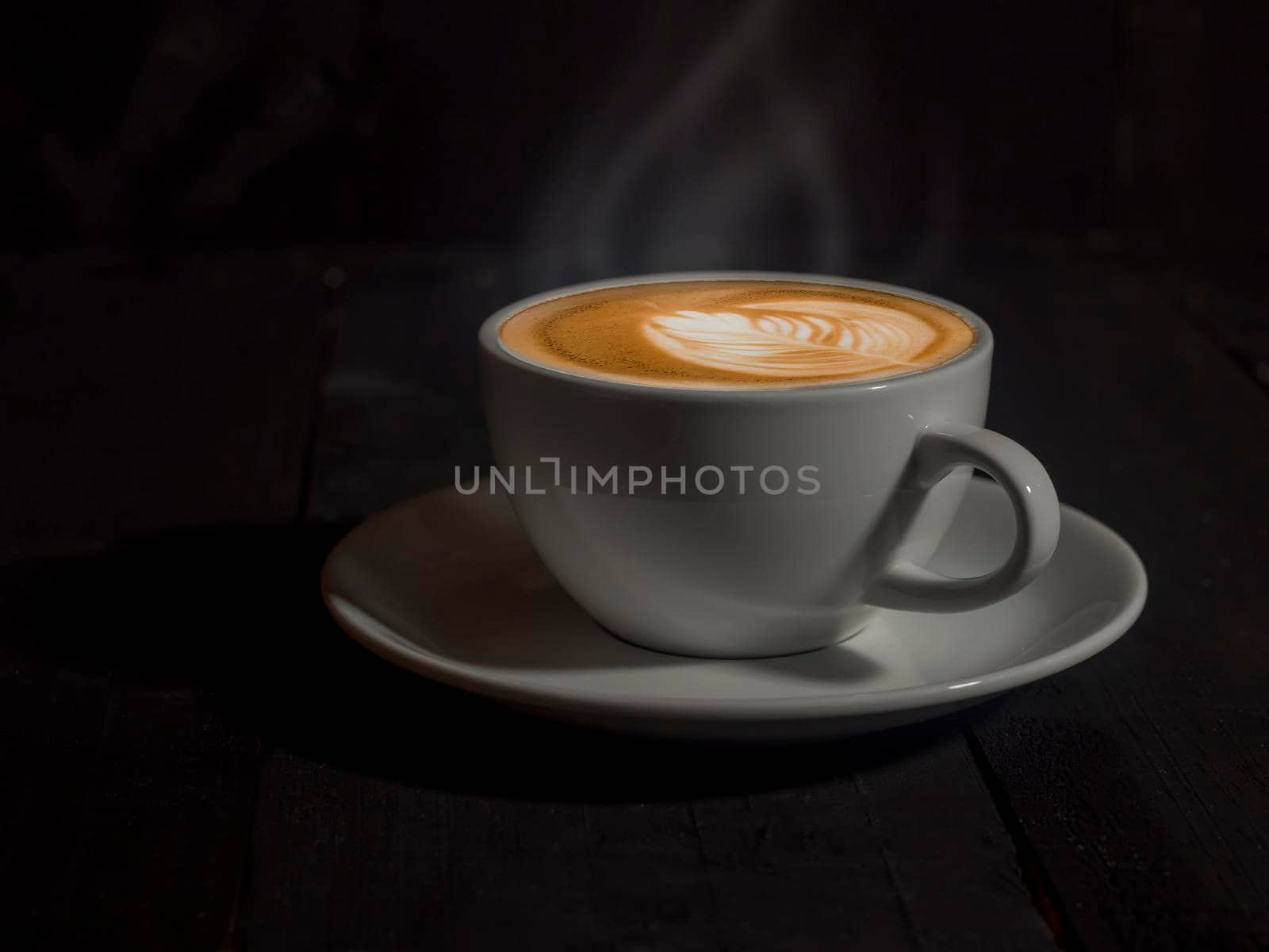 Coffee Mug on Wooden Table. Cup of coffee on wooden table. Close up hot coffe in white cup on wood table.