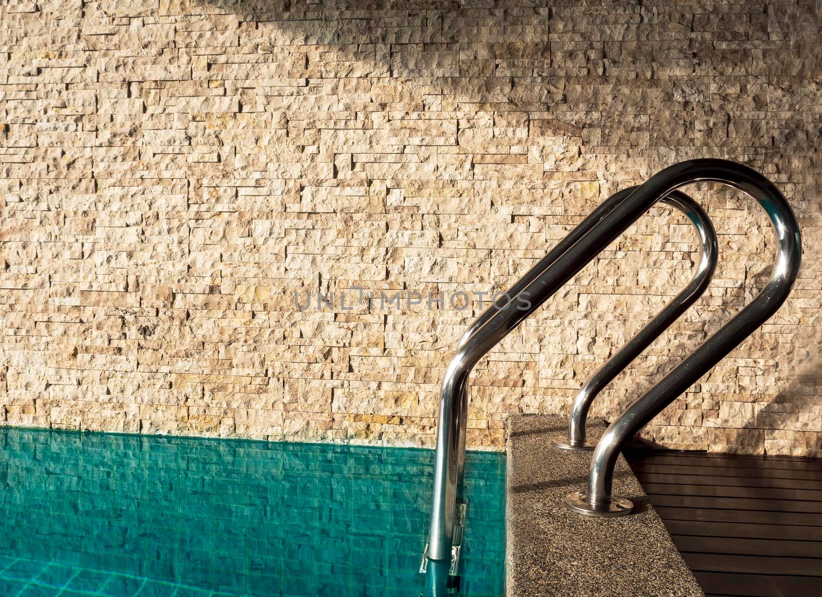 Side view of swiming pool handles near brick wall in hotel room. Close up pool handles