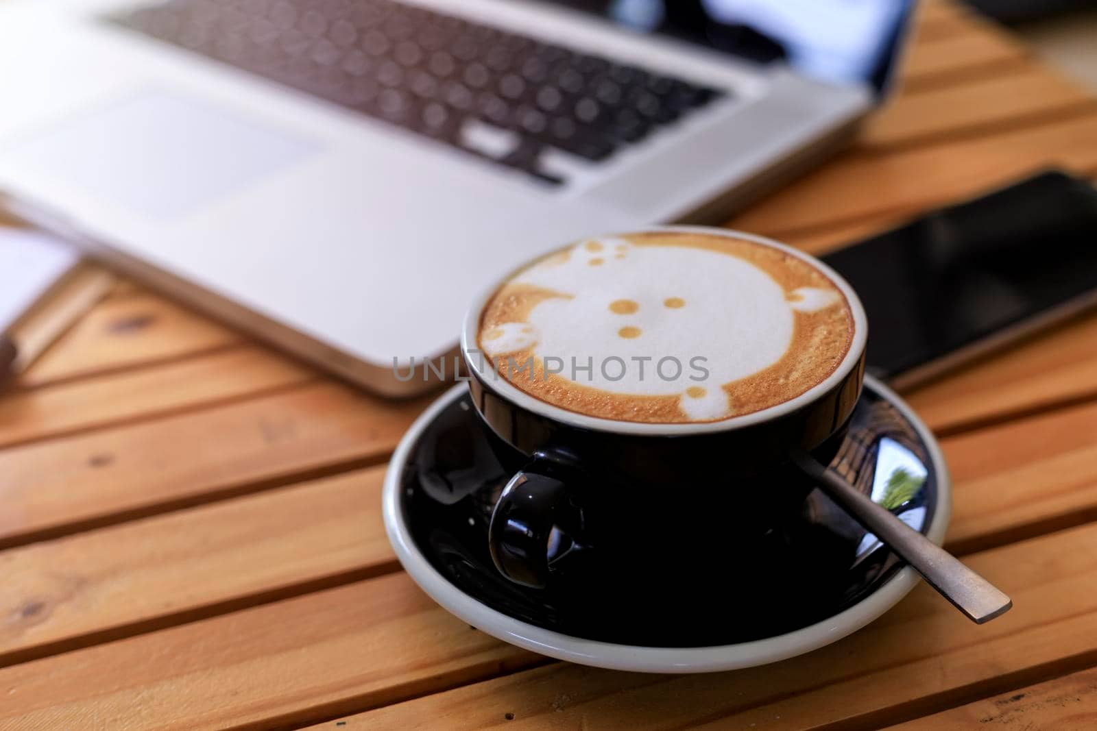 Top view hot coffee cup with blur laptop smarthphone and note book on wood table. office desk with smart phone laptop and coffee cup. Business concept. Process with vintage style